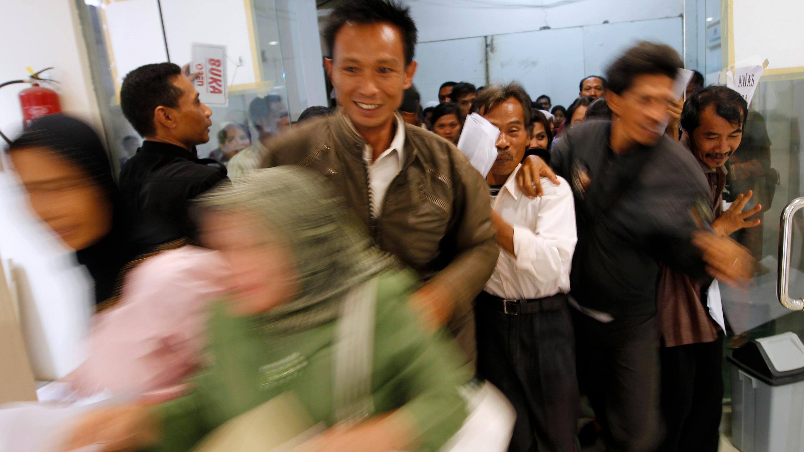 Photo shows many people jostling at the entrance of the hospital. 