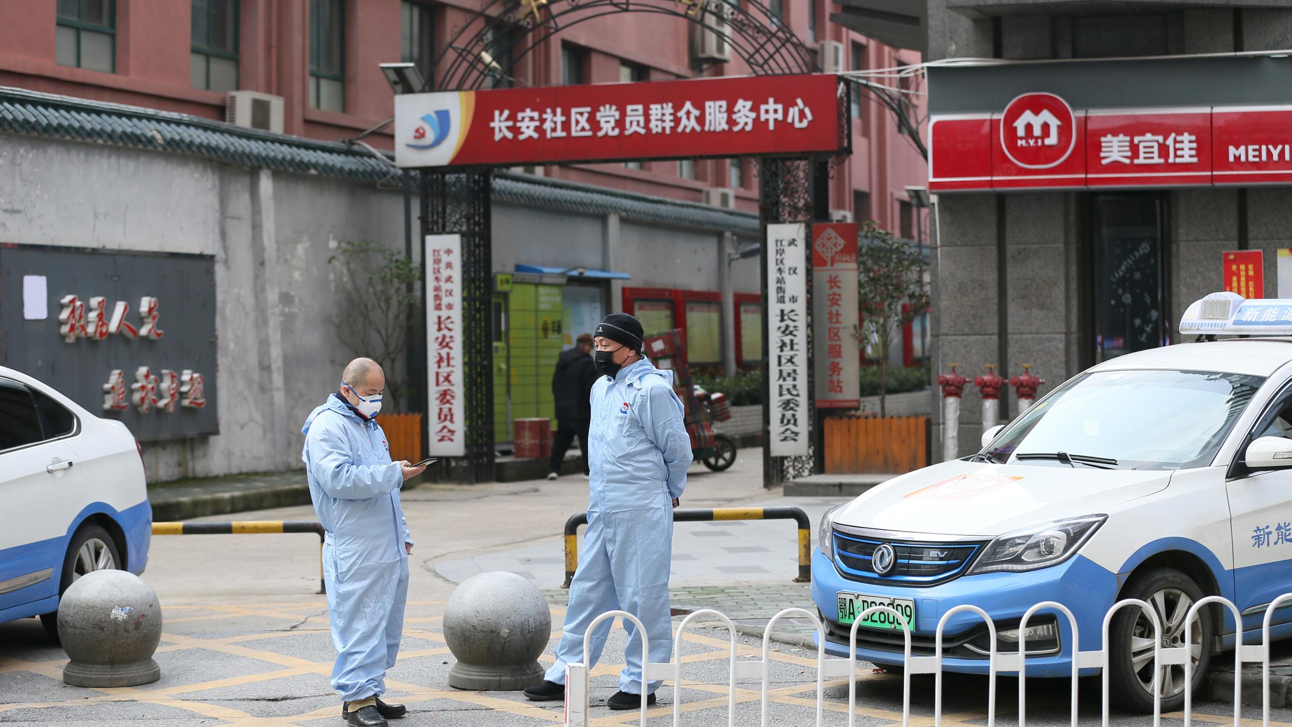 Photo shows two taxi drivers in masks standing on an almost abandoned street.