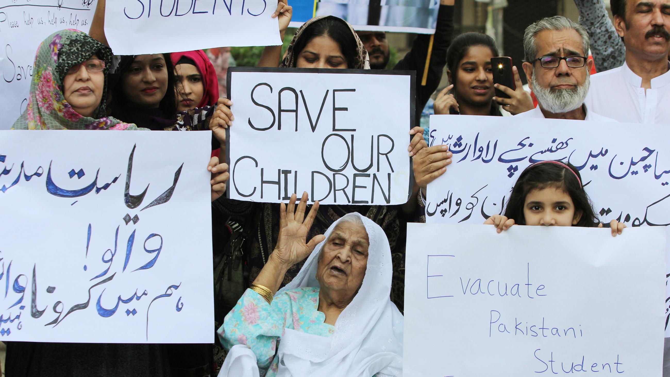 The photo shows a large crowd protesting with lots of picket signs. 