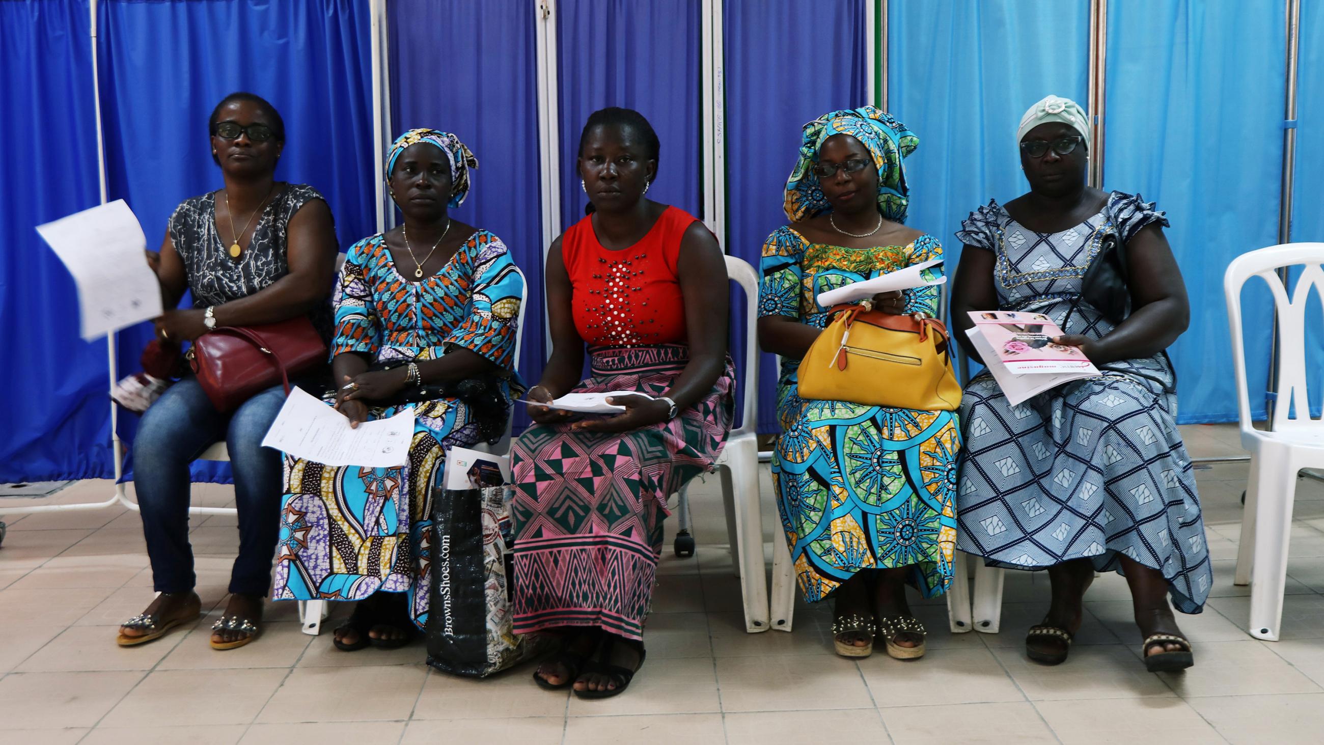 Image shows a row of several women wearing colorful clothes.