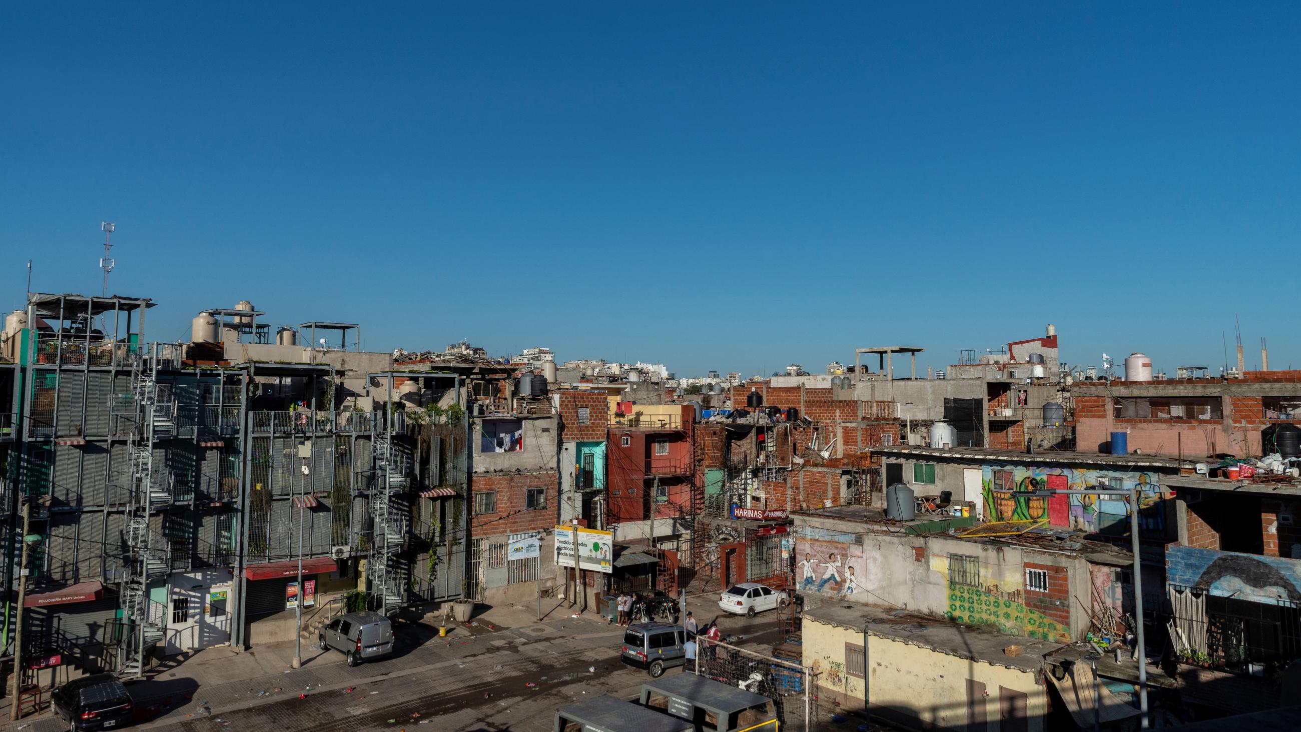 The photo is a neighborhood pictured from a high vantage point looking down on the street on a day with a grilliant clear blue sky. 