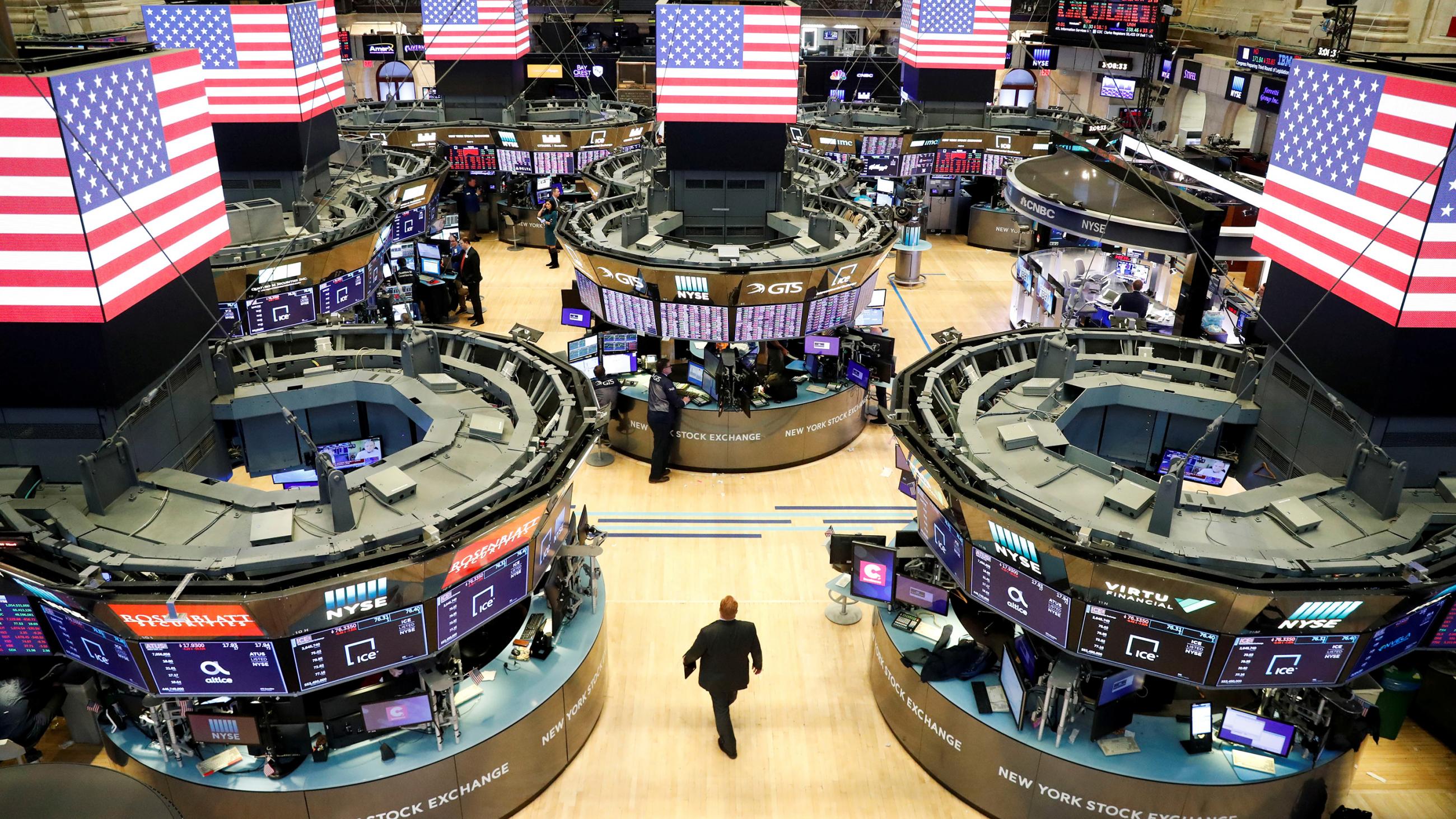 The photo shows the floor of the stock exchange emptied of most people. 