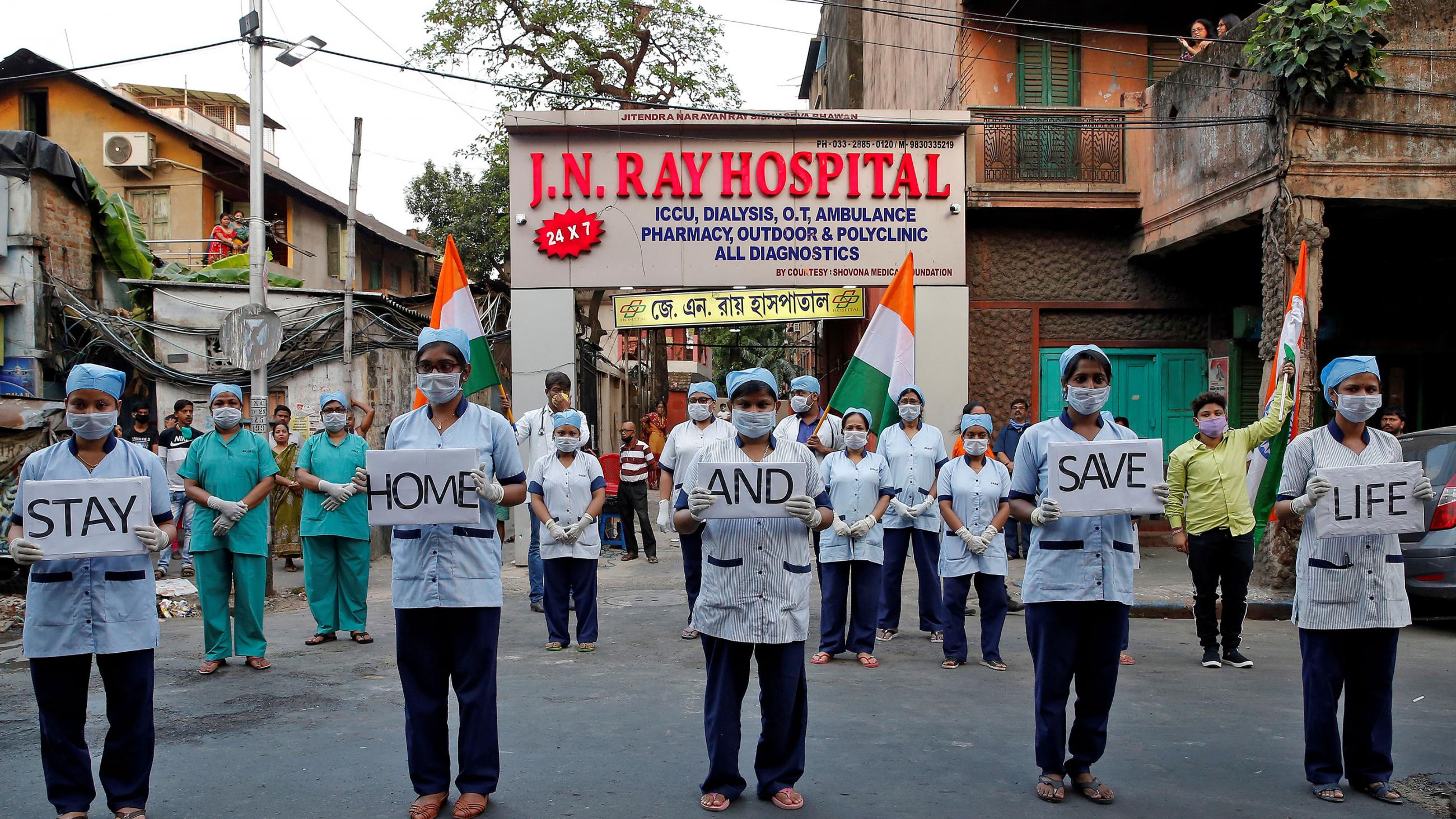  The photo shows the medical staff standing in front of the health center holding placards. 