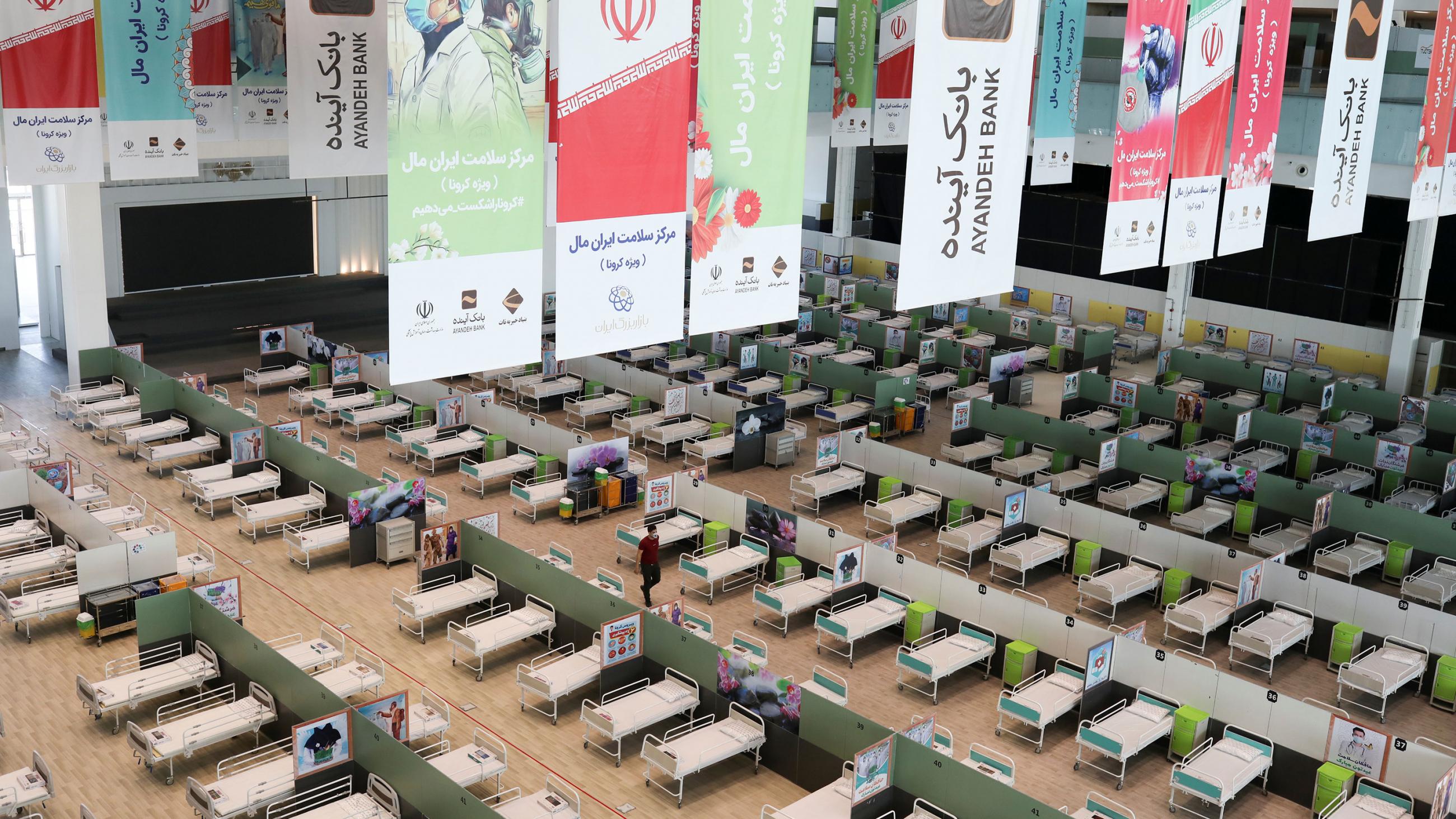 The photo shows a massive interior space with row upon row of bed frames lying waiting for patients. 