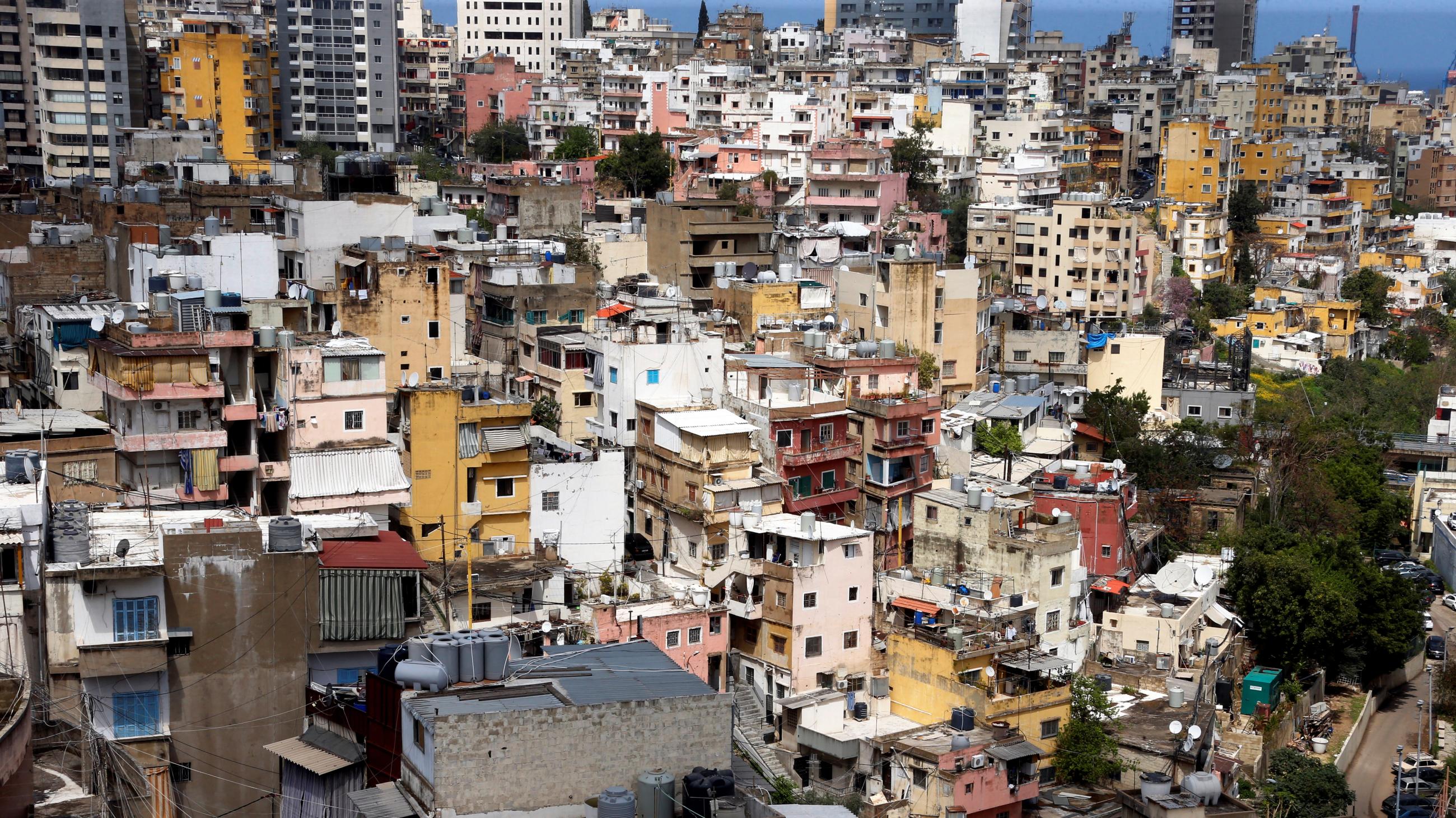 Picture shows a view of a section of city filling the fame with buildings but very few people apparent on the streets. 