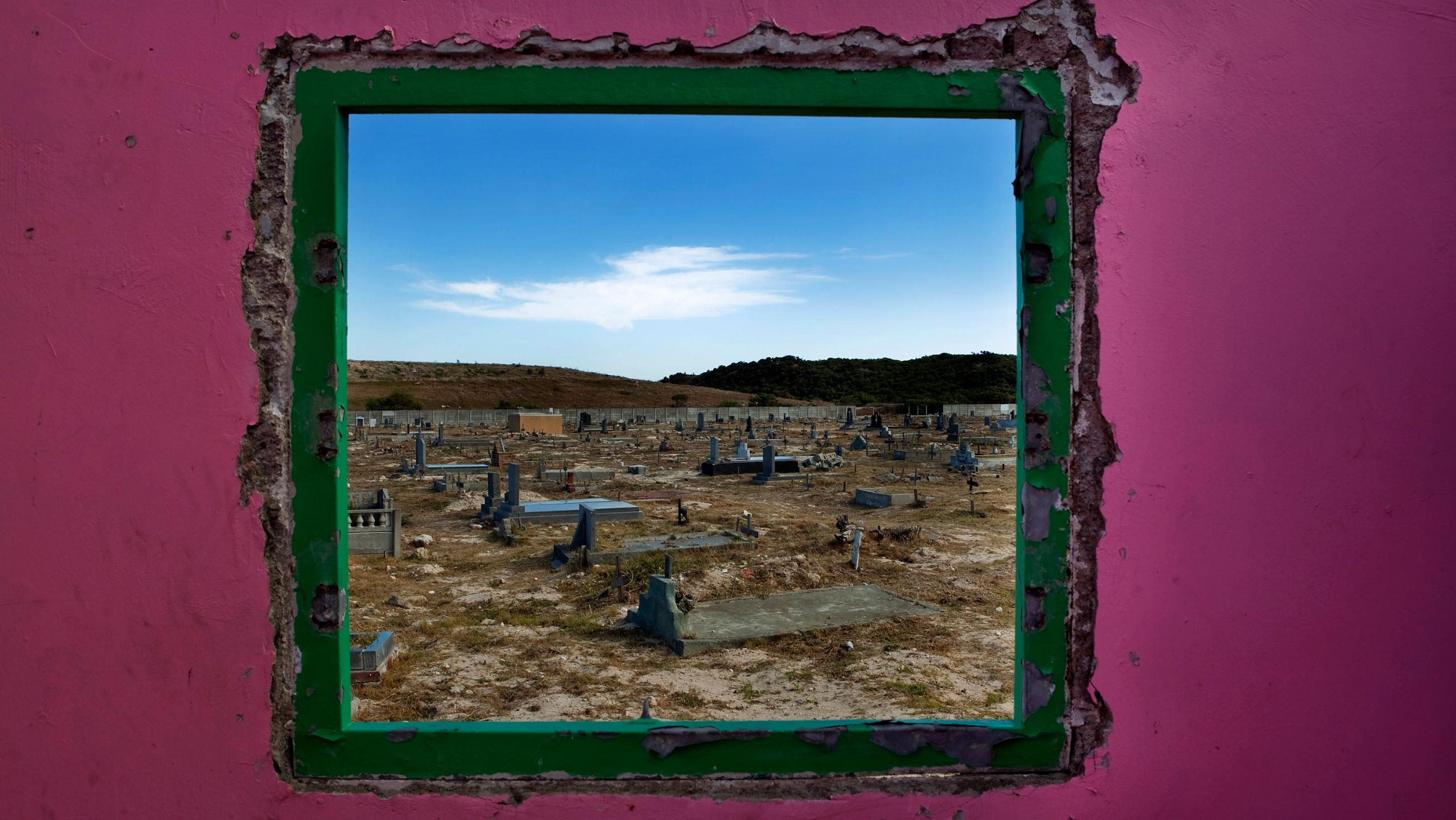 Picture shows a graveyard seen through an open window. 
