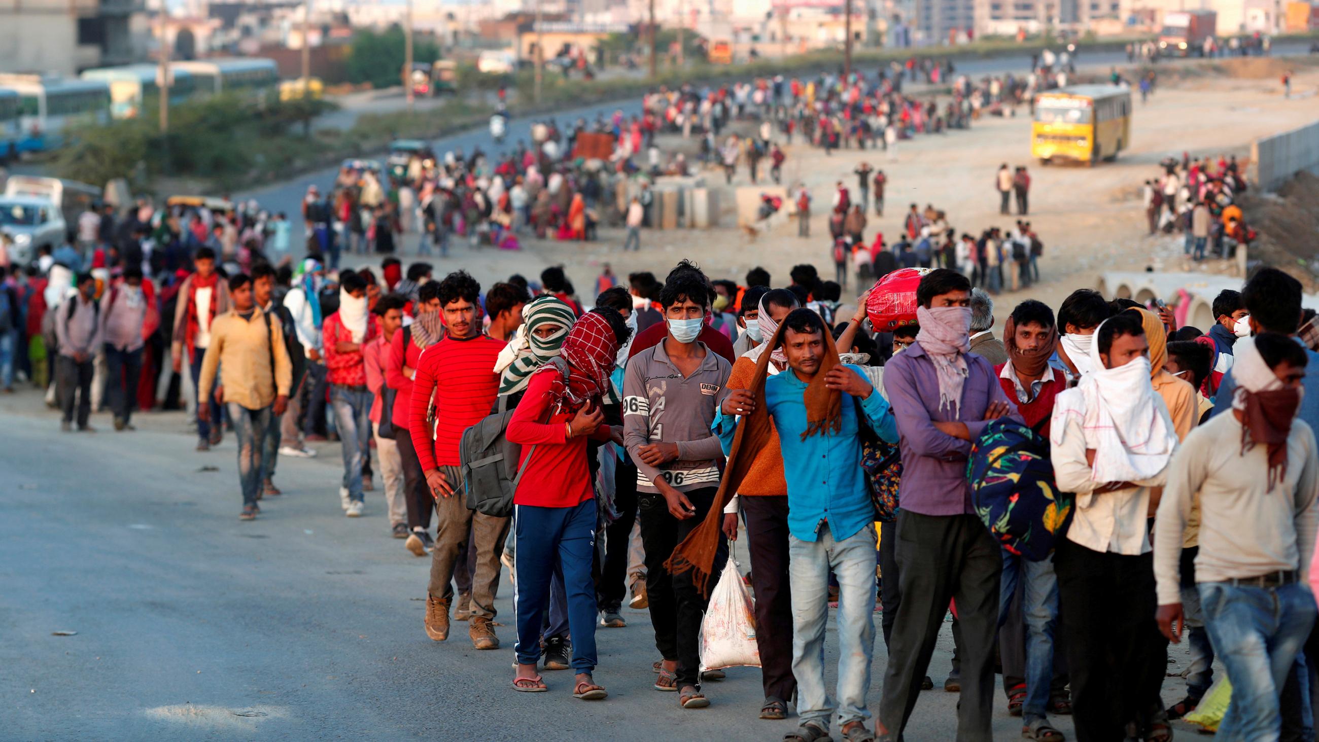 The photo shows a huge stream of people walking down a long road with the city to their backs far away. 