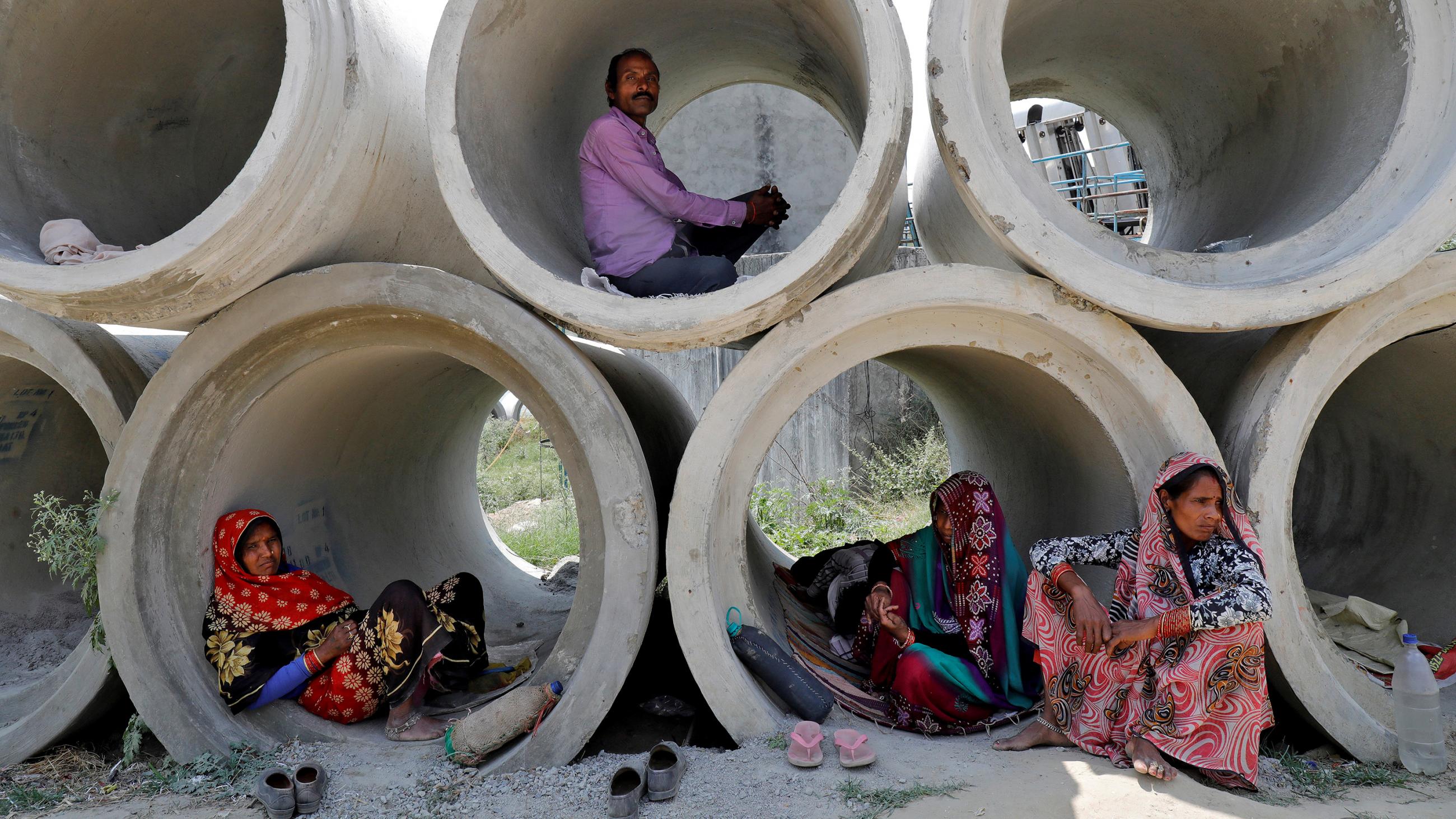 This is a powerful image of people inside stacked cement pipes of large enough diameter for them to camp out in. 