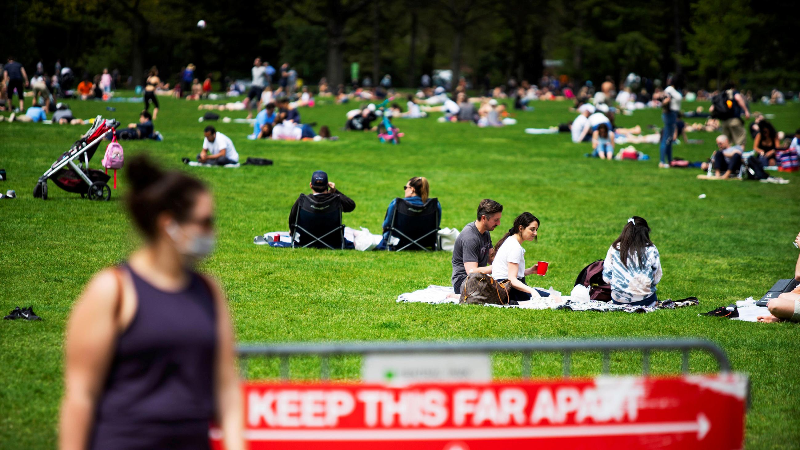 The photo shows people enjoying the day in the park, albeit somewhat far apart. 