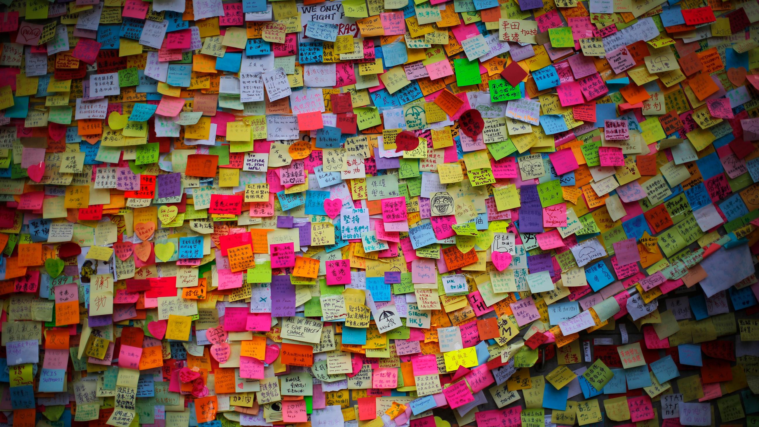 Picture shows a wall covered with thousands of stickies. 