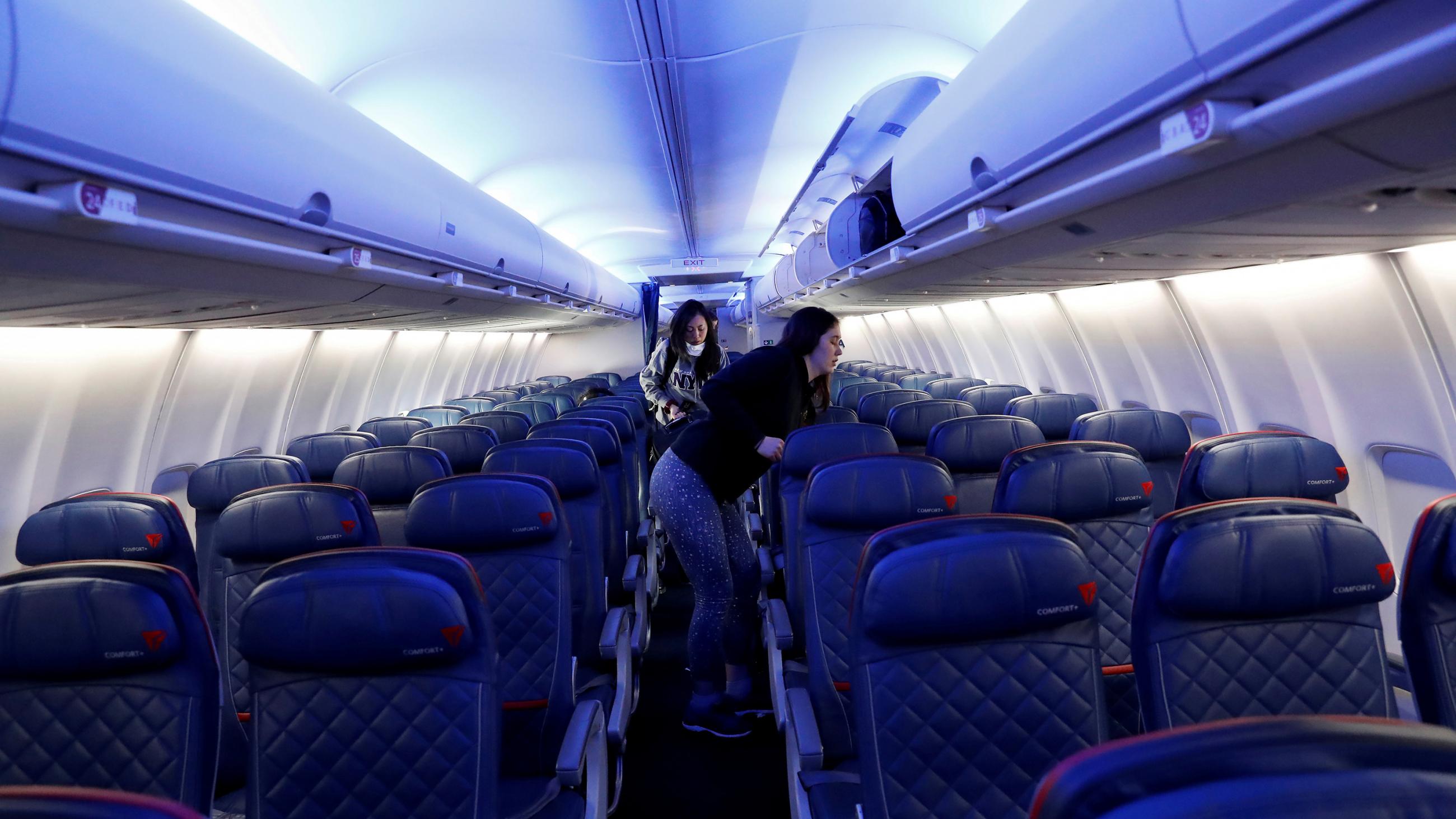 The photo shows a large jet passenger plane nearly empty of people. 