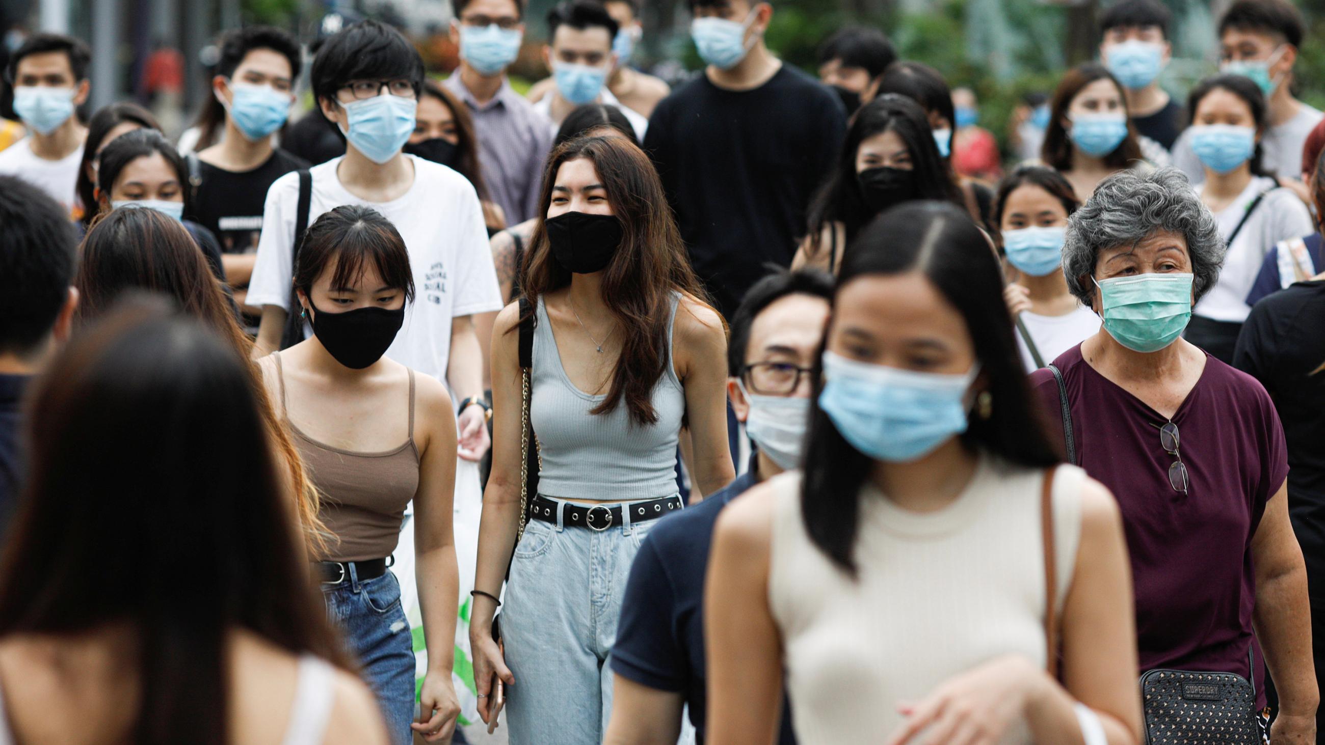 The photo shows a busy street bustling with foot traffic, and strikingly every single person appears to be wearing a mask. The photo shows 