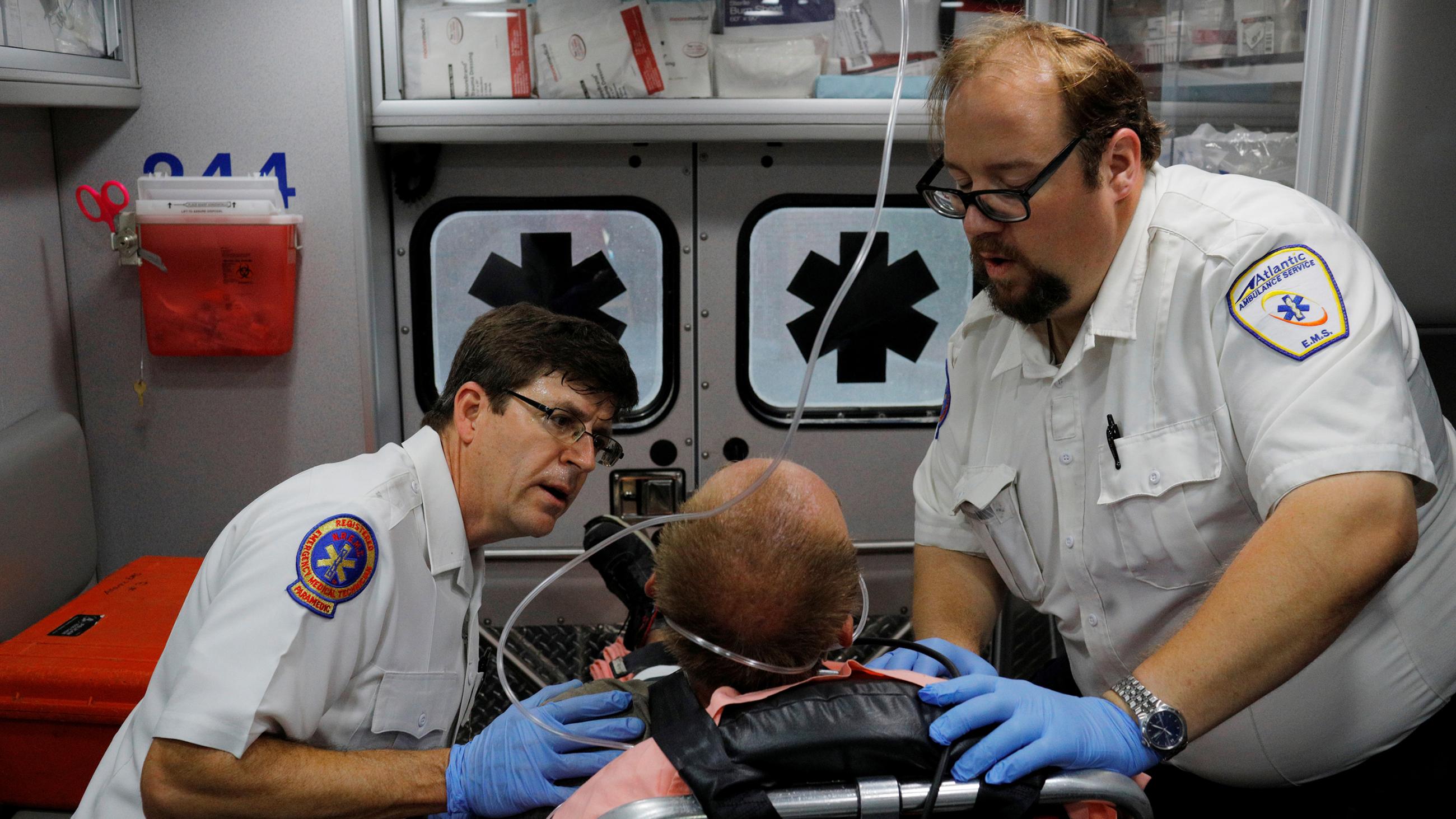The photo shows the two medics administering to a man in a gurney. 