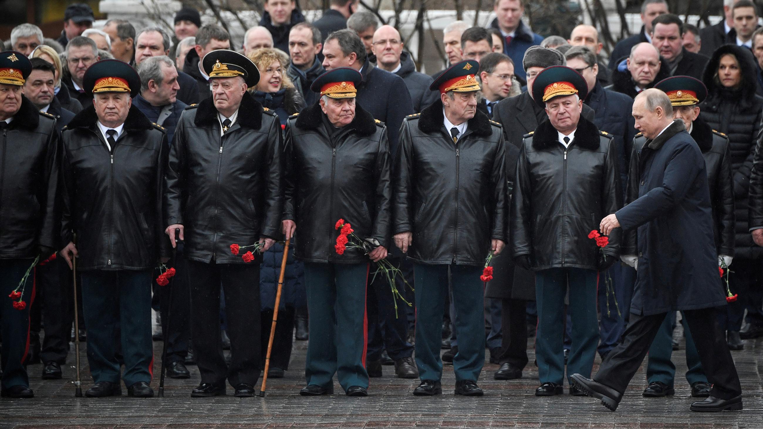 The photo shows Putin walking past a line of military top brass.