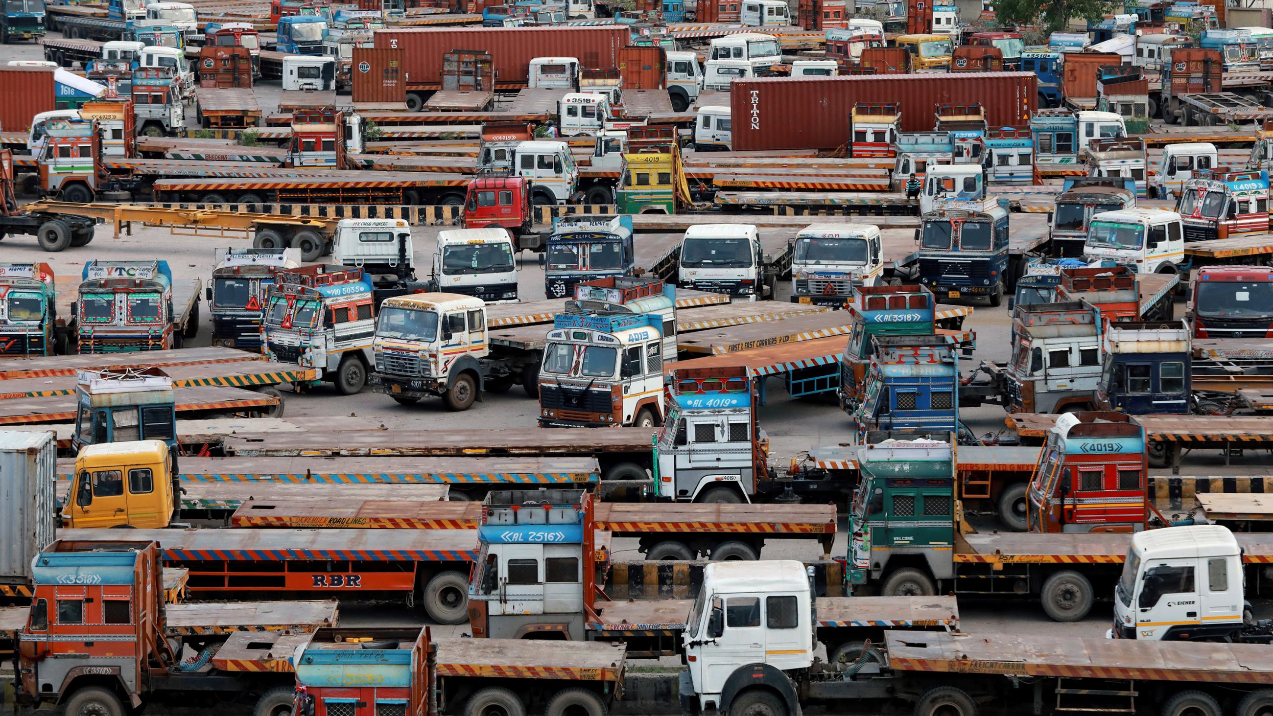 The photo shows a huge collection of large haul trucks packed together in a large parking area. 