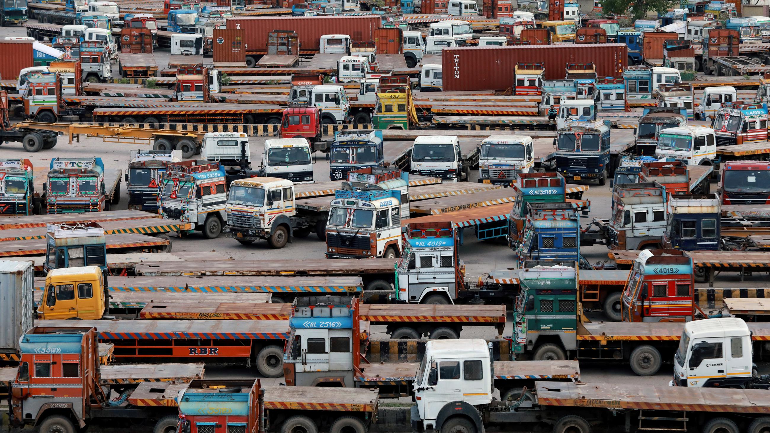The photo shows a huge collection of large haul trucks packed together in a large parking area.