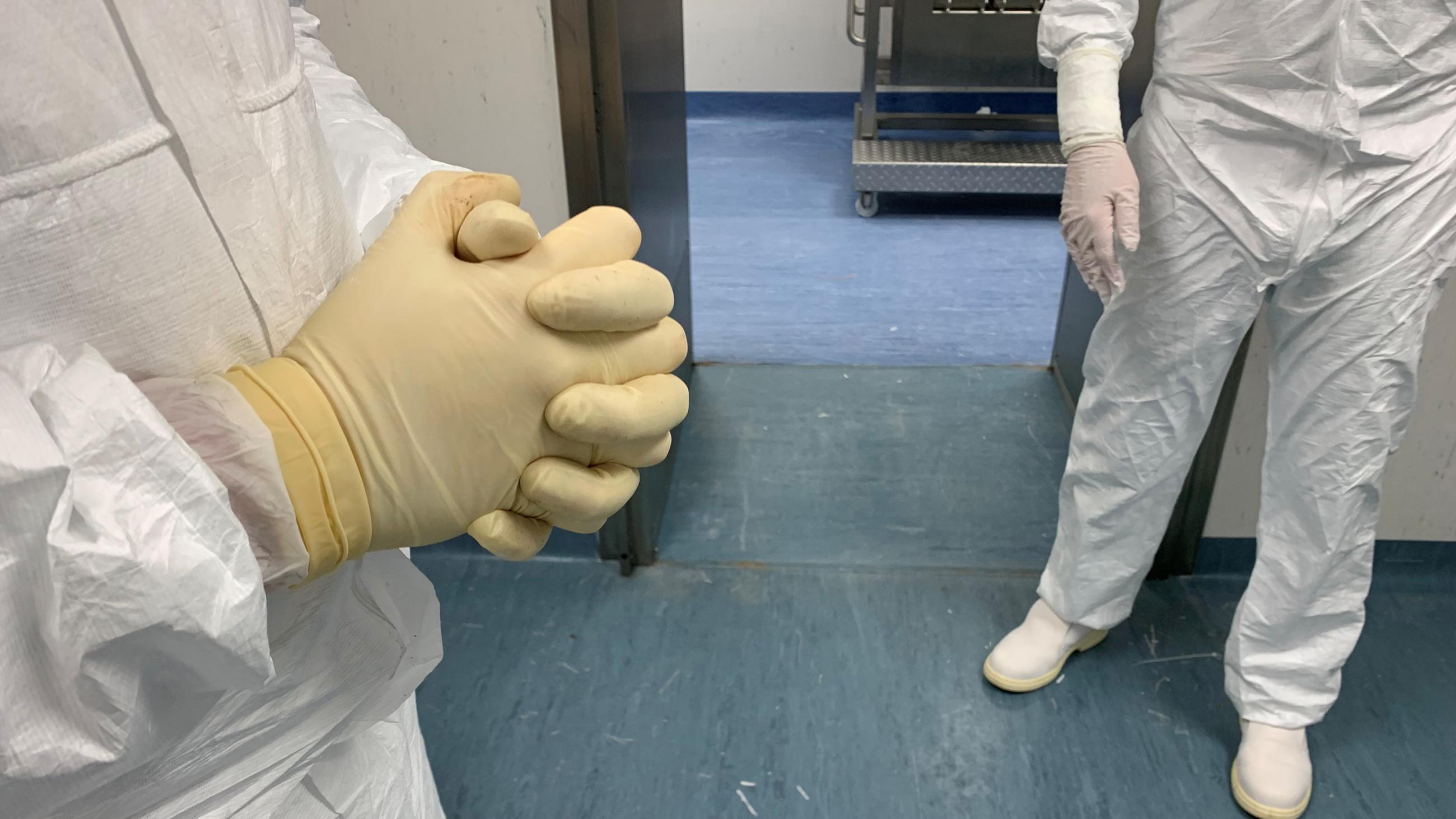 The photo shows two workers' torsos.