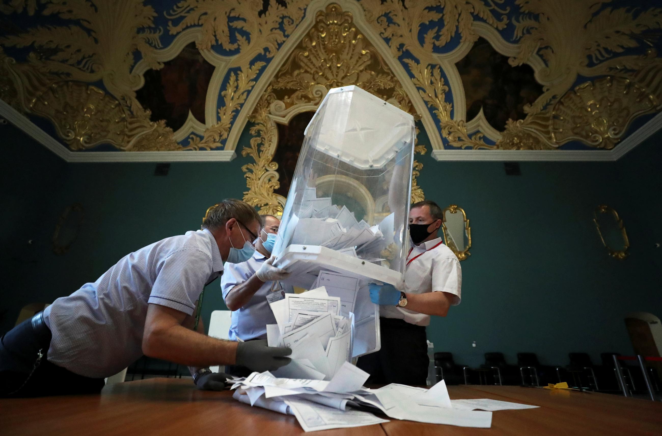 Members of a local electoral commission empty a ballot box at a polling station following a seven-day nationwide vote on constitutional reforms, in Moscow, Russia, July 1, 2020. 