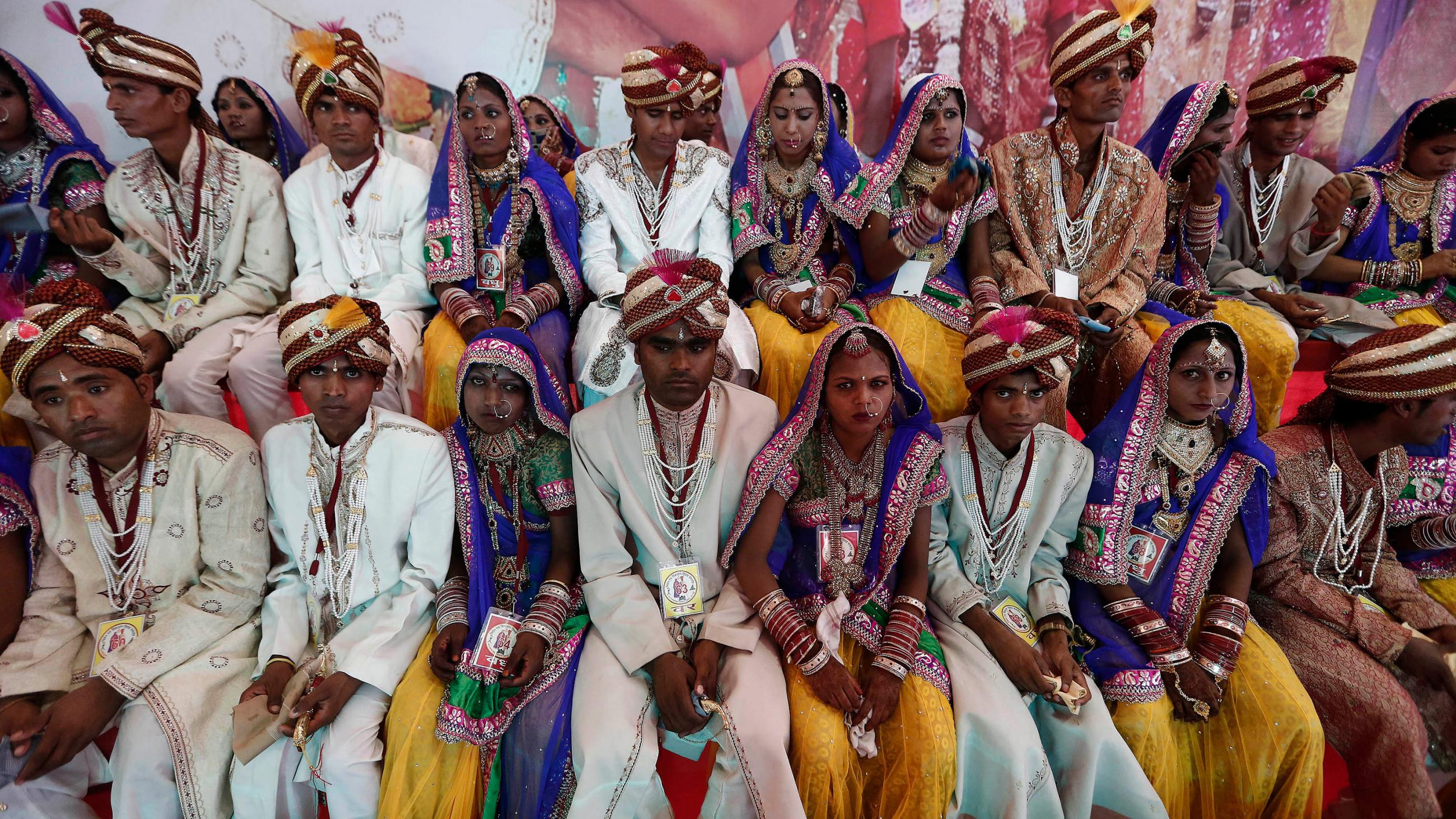 The photo shows a huge number of couples in fancy wedding garb. 