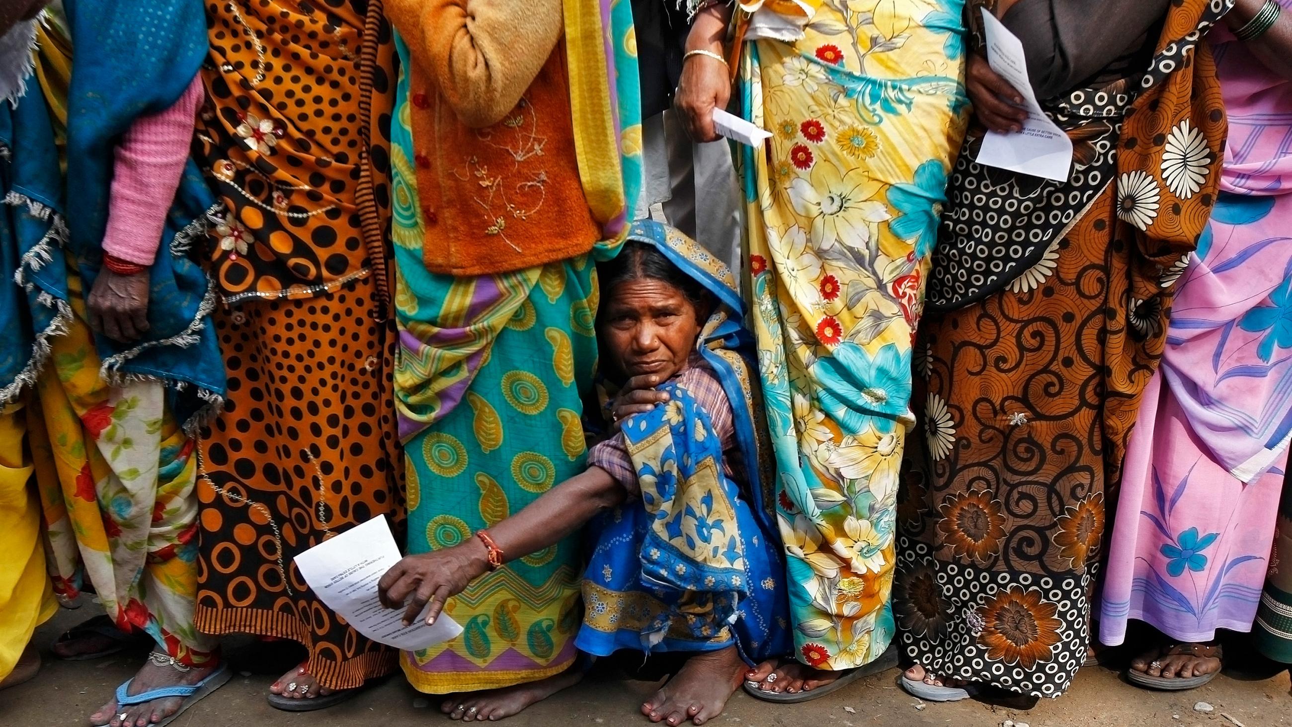 The photo shows a line of people with one peeking through near the ground. 