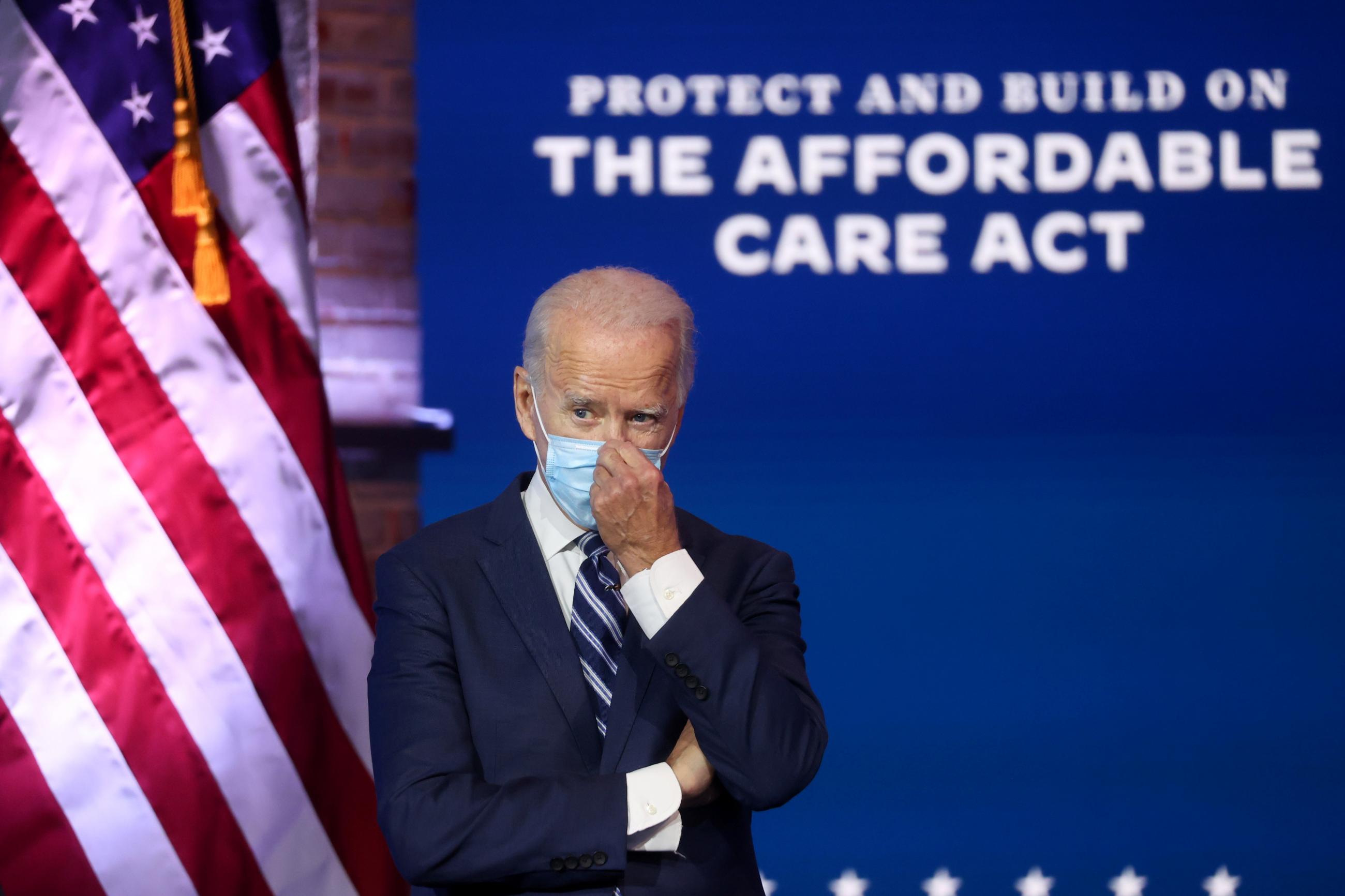 U.S. President-elect Joe Biden adjusts his face mask after delivering remarks about health care and the Affordable Care Act (Obamacare) during a brief news conference at the theater serving as his transition headquarters in Wilmington, Delaware, U.S., November 10, 2020.