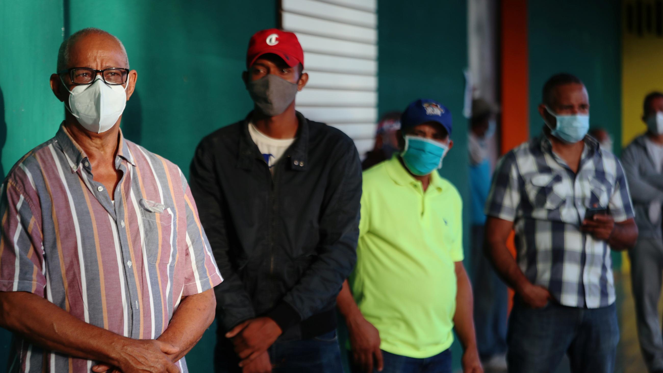 People wearing protective masks stand in line to cast their votes in the general election during the outbreak of the coronavirus disease (COVID-19), in Santiago, Dominican Republic July 5, 2020.