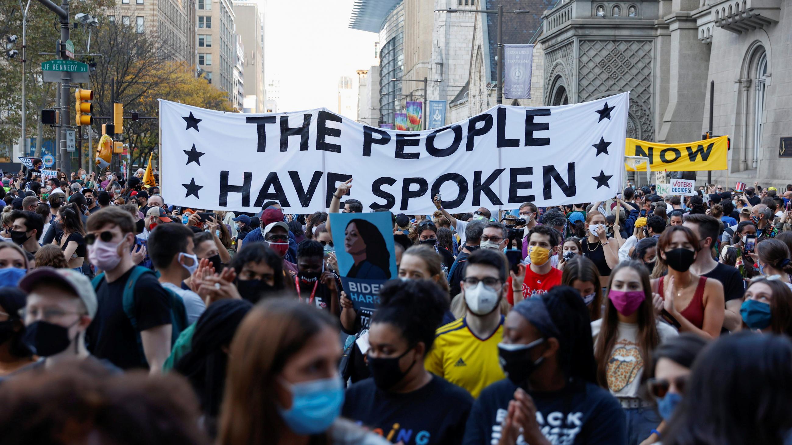 Densely packed crowds celebrate, carrying a sign that reads, "The People Have Spoken," after former Vice President Joe Biden is declared the winner of U.S. presidential race in Philadelphia, Pennsylvania on November 7, 2020.