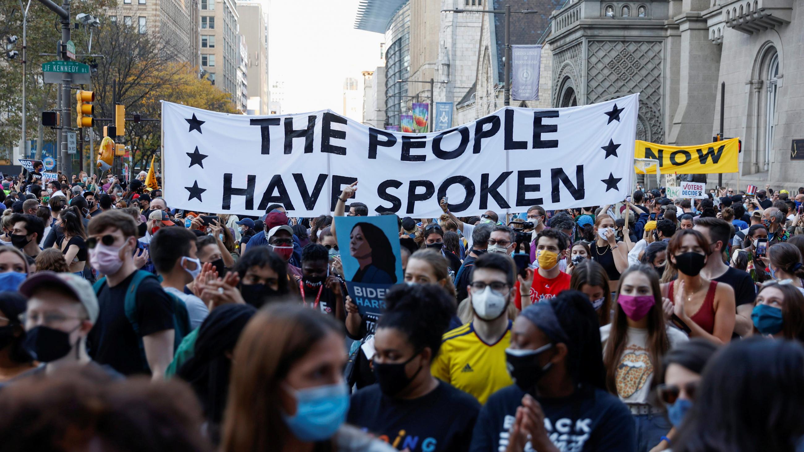 Densely packed crowds celebrate, carrying a sign that reads, "The People Have Spoken," after former Vice President Joe Biden is declared the winner of U.S. presidential race in Philadelphia, Pennsylvania on November 7, 2020.
