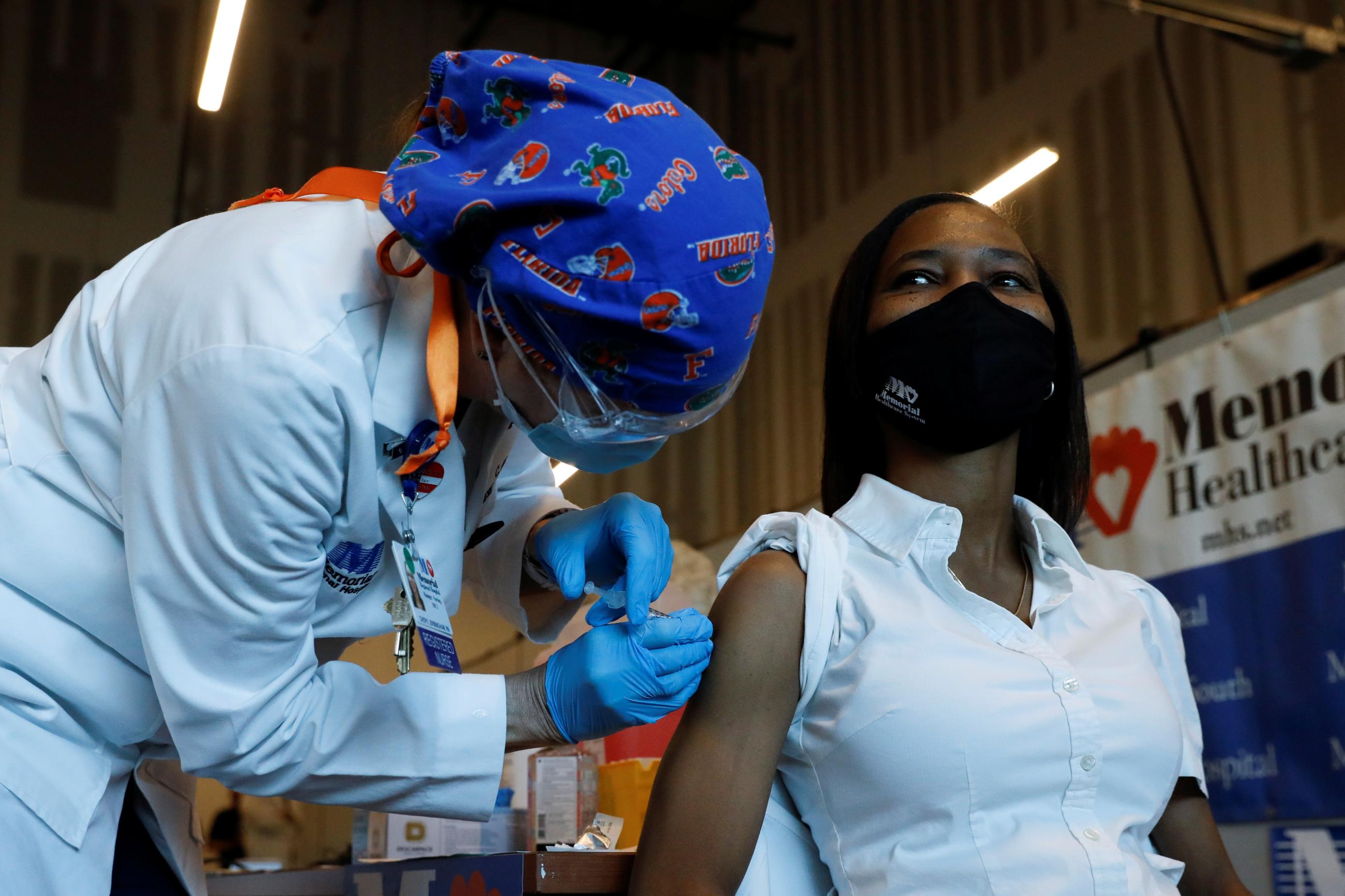 A nurse administers the Pfizer-BioNTech COVID-19 Vaccine to another registered nurse at Memorial Health-care System facility in Miramar, Florida on December 14, 2020.
