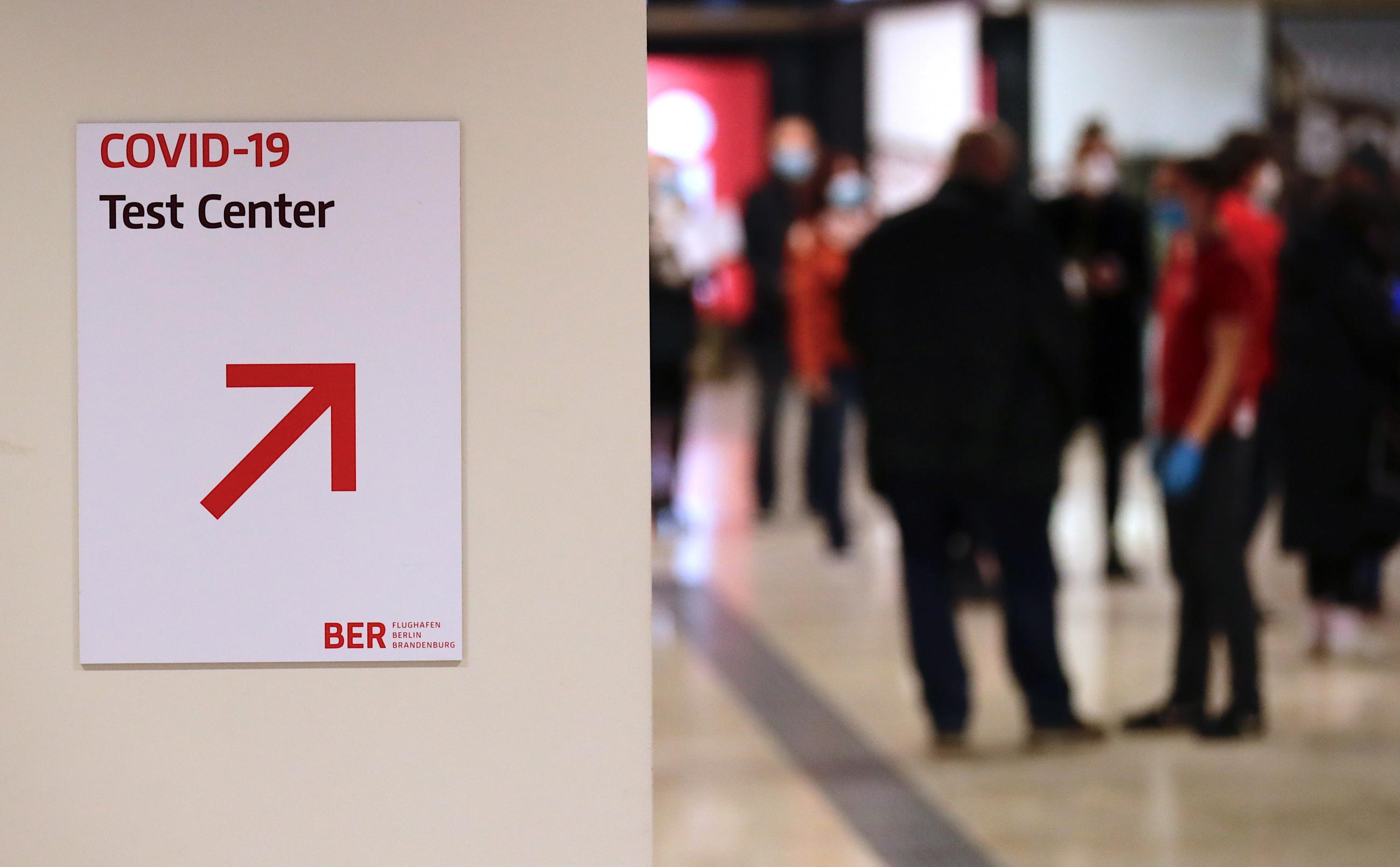 People wait at a a coronavirus testing center at the Berlin Brandenburg airport, as EU countries begin closing their doors to travelers from the United Kingdom amid alarm about a rapidly spreading strain of coronavirus, in Schoenefeld, Germany