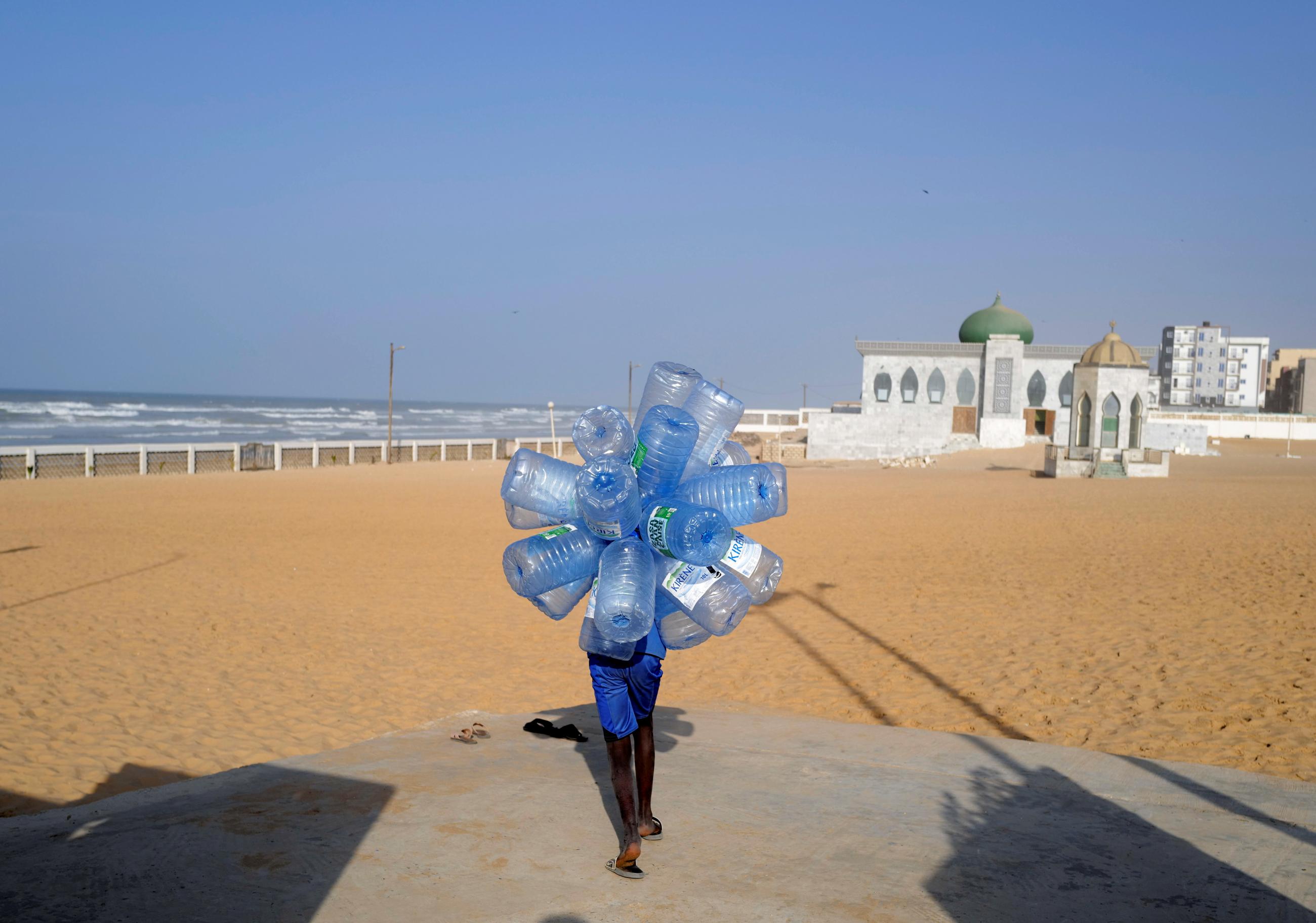 A boy carries jerricans to be filled at Khabrou Layene mosque, as the spread of the coronavirus disease continues, in Yoff neighbourhood of Dakar, Senegal on January 12, 2021. 