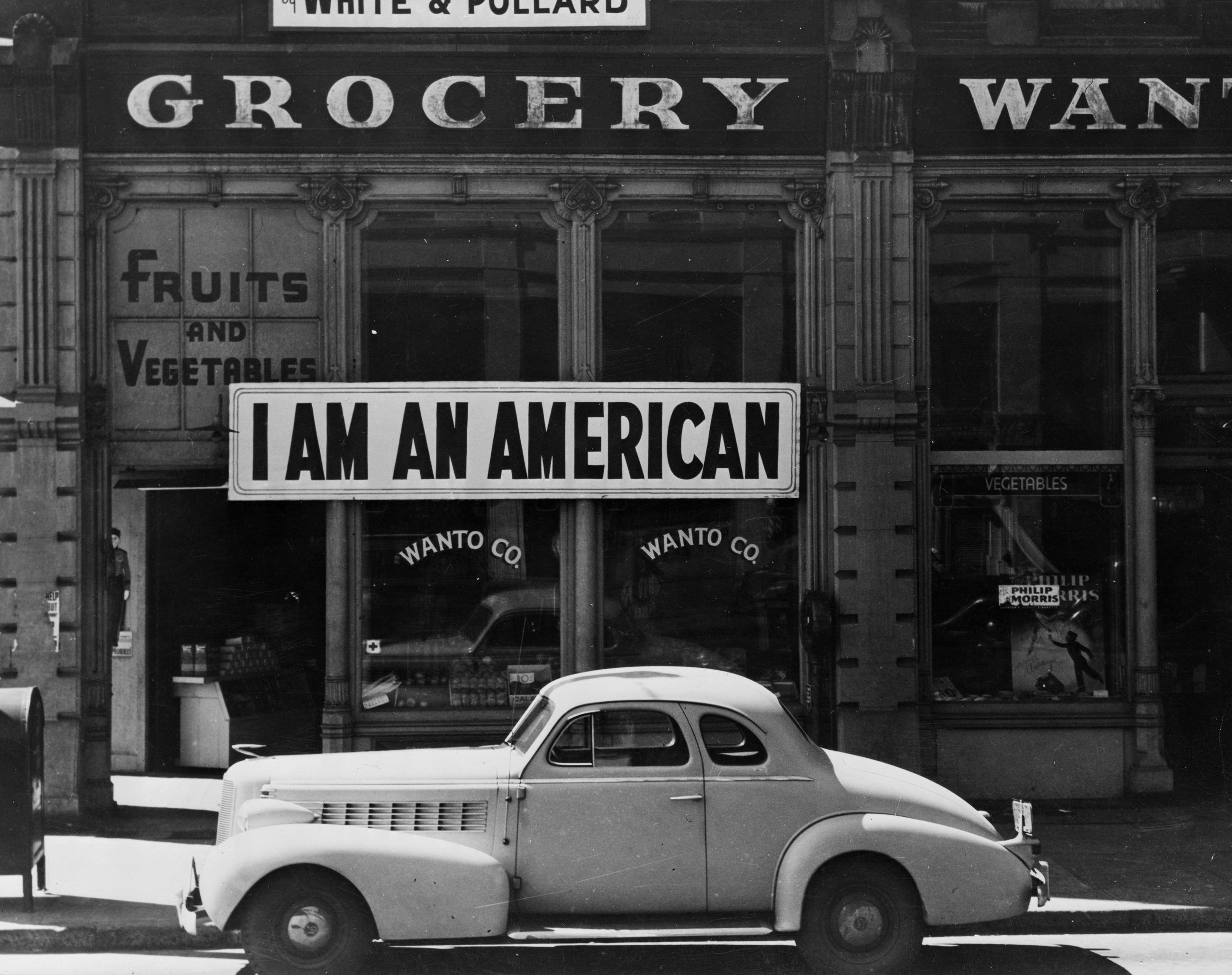 A large sign reading "I am an American" is placed in the window of a store  following orders to persons of Japanese descent to evacuate from certain West Coast areas in Oakland, California  in 1942.