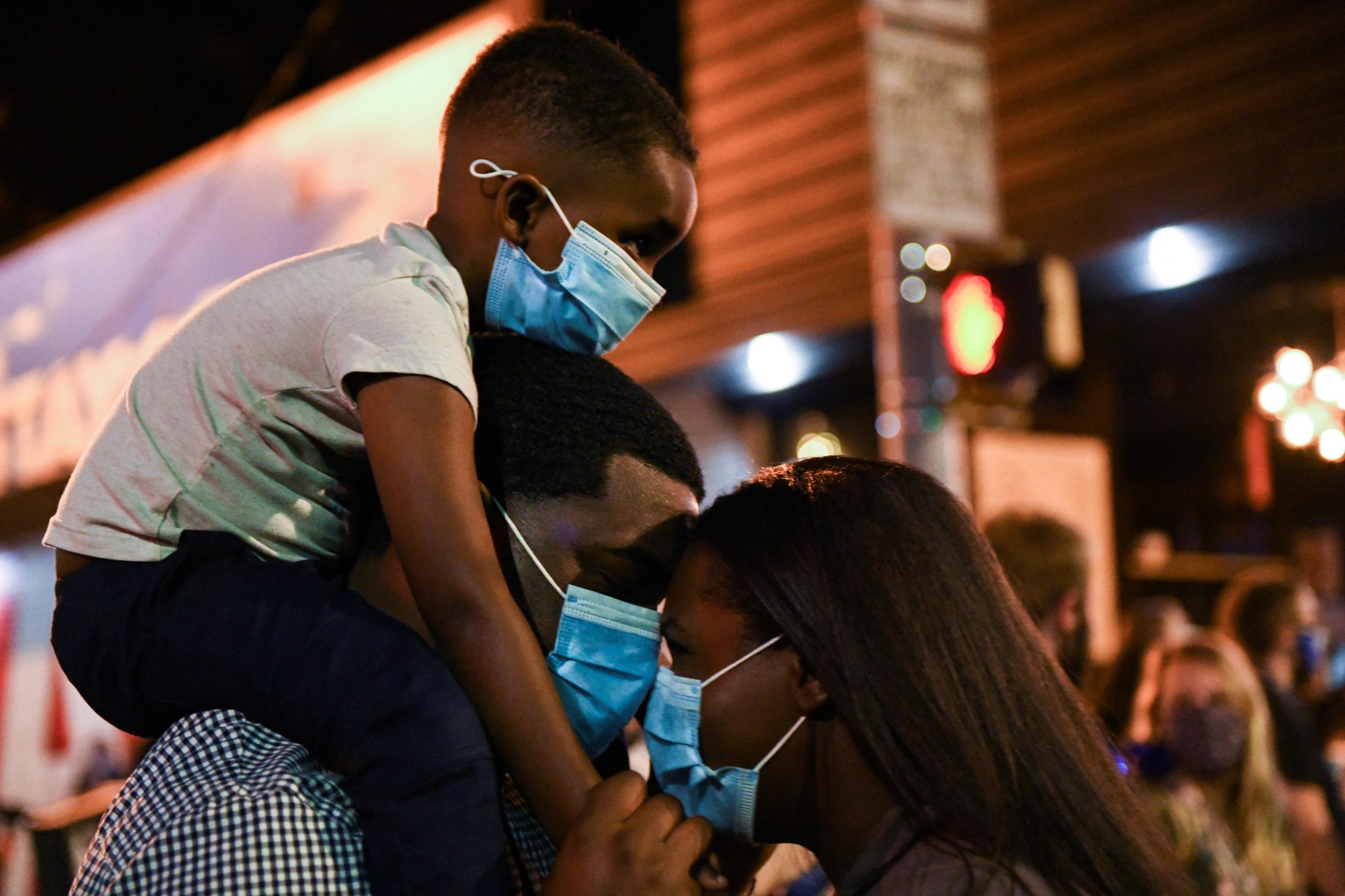 A family reacts as they listen to Democratic presidential nominee Joe Biden and vice presidential nominee Kamala Harris' speeches after media announced they won the 2020 U.S. presidential election, in Atlanta, Georgia, U.S., November 7, 2020.