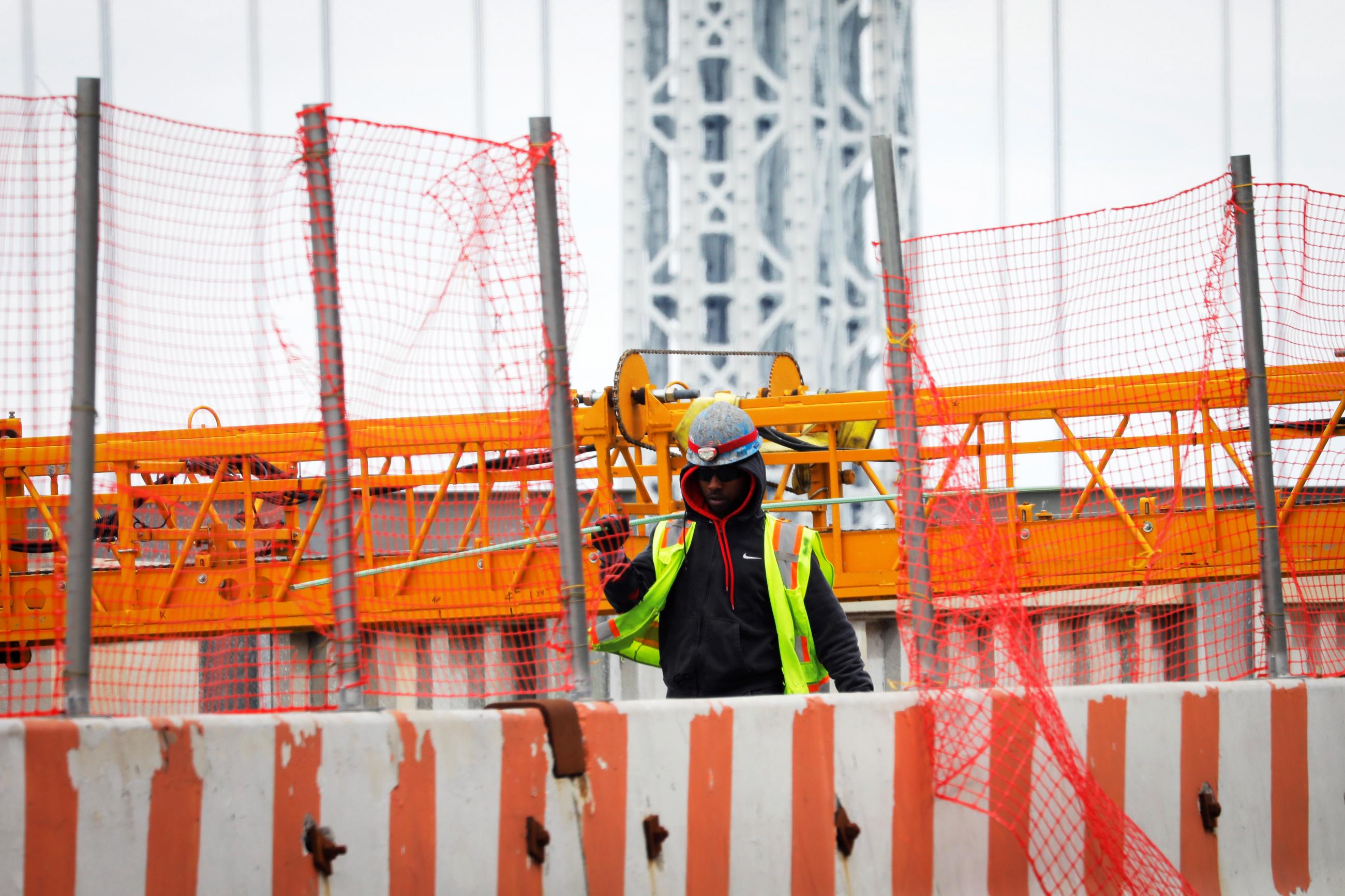 A construction worker carries a steel bar at the site of a large public infrastructure reconstruction project of an elevated roadway and bridges in upper Manhattan in New York City, New York, U.S., April 22, 2021