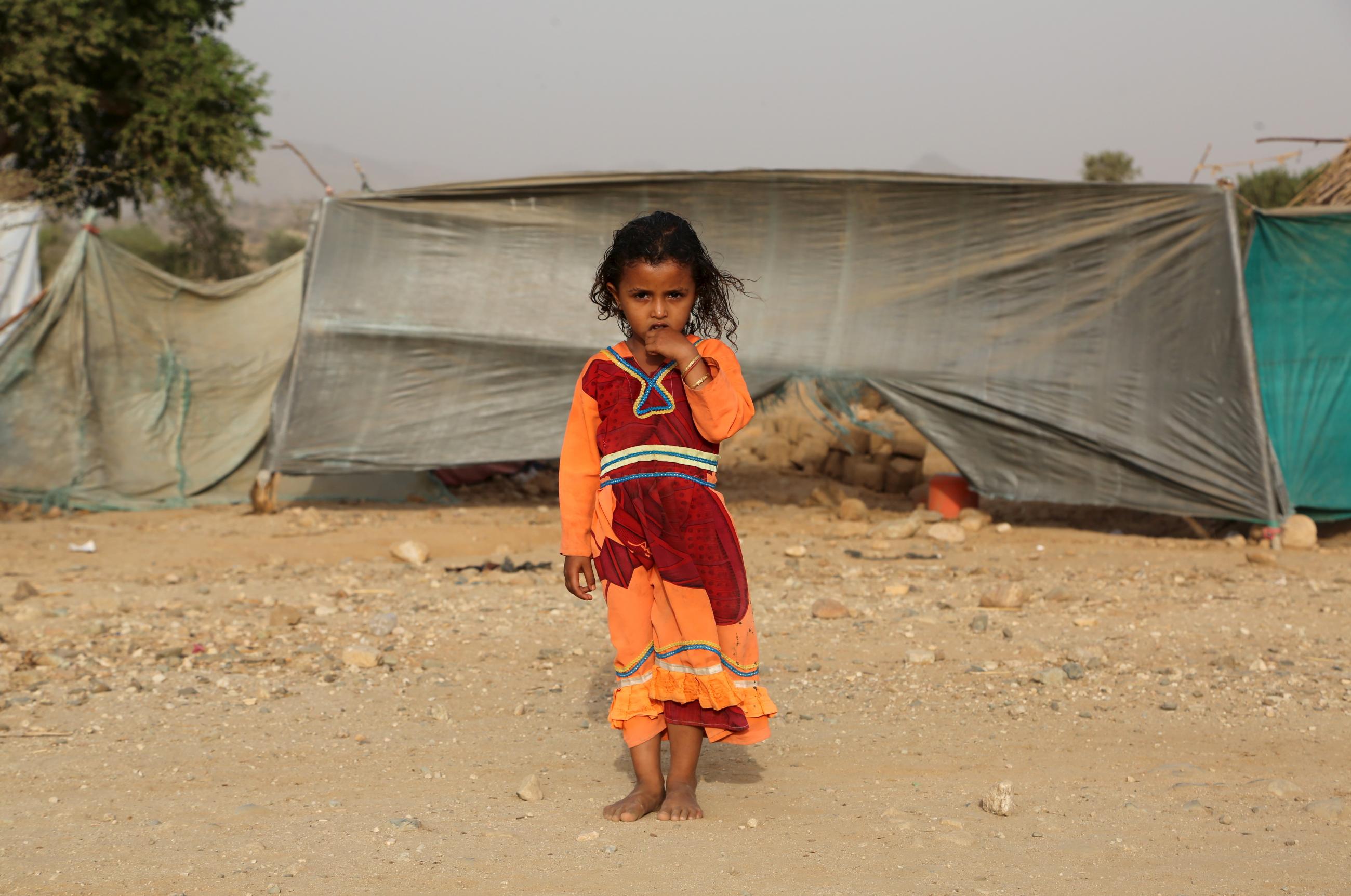 A girl stands outside her family’s hut at the Shawqaba camp for people forced to leave their villages due to war in Yemen's northwestern province of Hajjah. Photo taken on March 12, 2016.