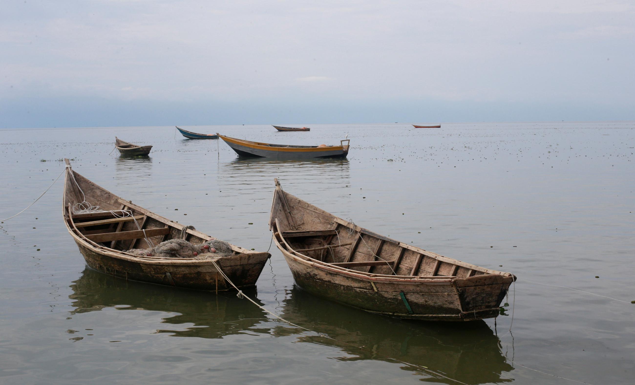 Fishing boats used by Congolese people fleeing ethnic fighting in the Democratic Republic of Congo float on the shore of Lake Albert, Uganda on March 19, 2018. REUTERS/James Akena