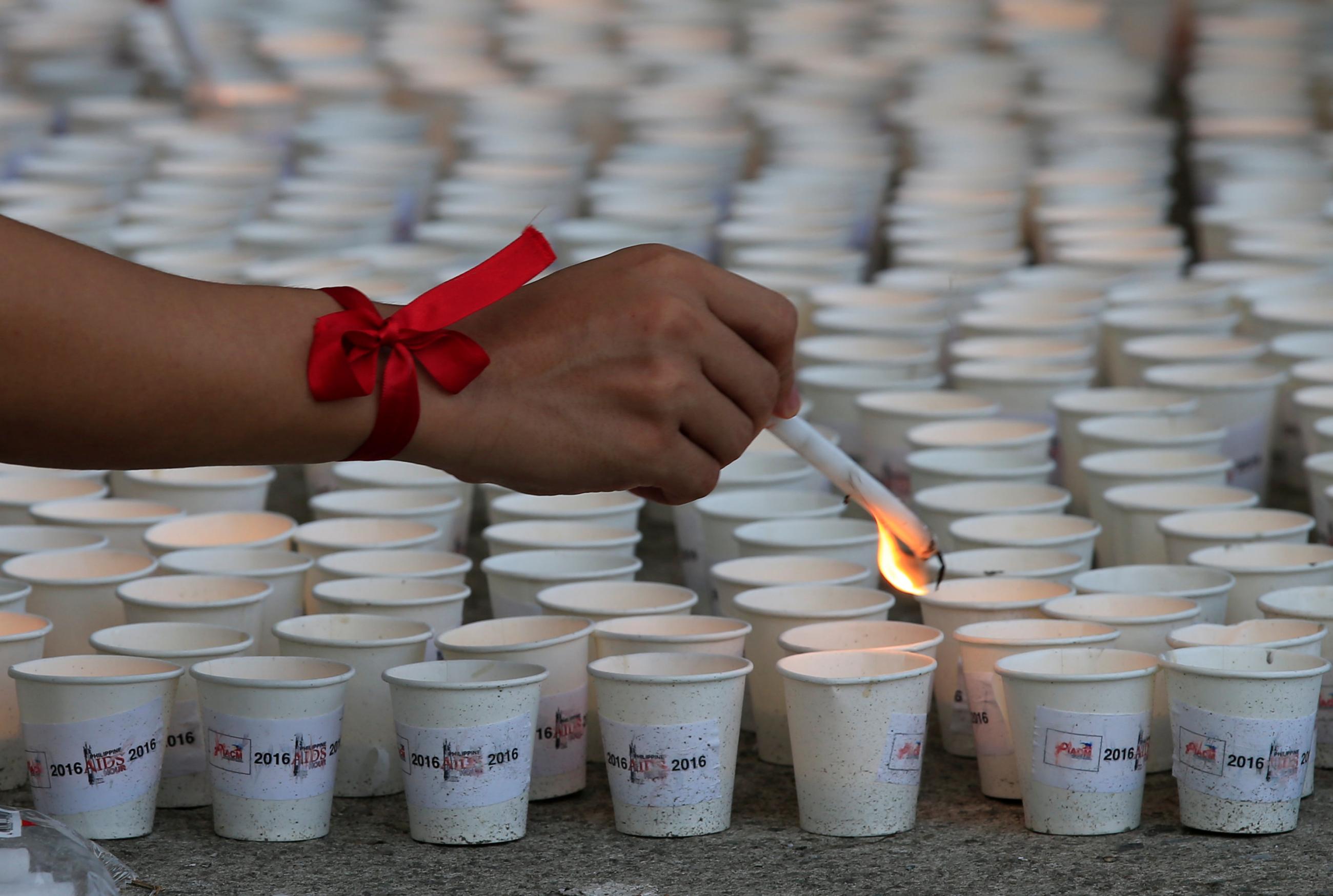 A supporter lights some of the 1,638 candles representing the number of lives lost due to HIV/AIDS in the Philippines. Photo taken on International AIDS Candlelight Memorial Day in Quezon City, Philippines on May 14, 2016. REUTERS/Romeo Ranoco