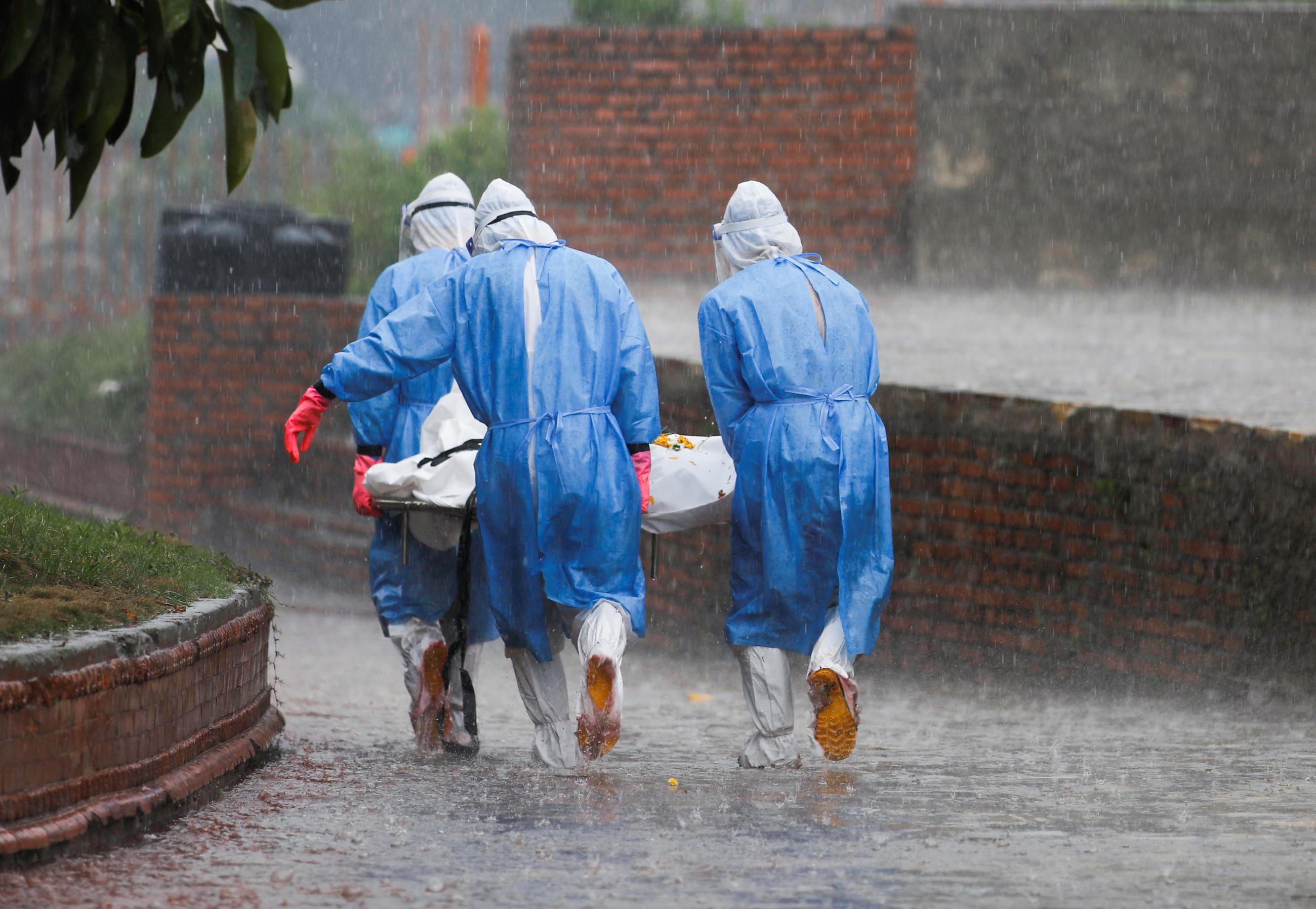 Members of Nepal Army wearing personal protective equipment carry the body of a person who died from the coronavirus disease in Kathmandu, Nepal on May 11, 2021. REUTERS/Navesh Chitrakar