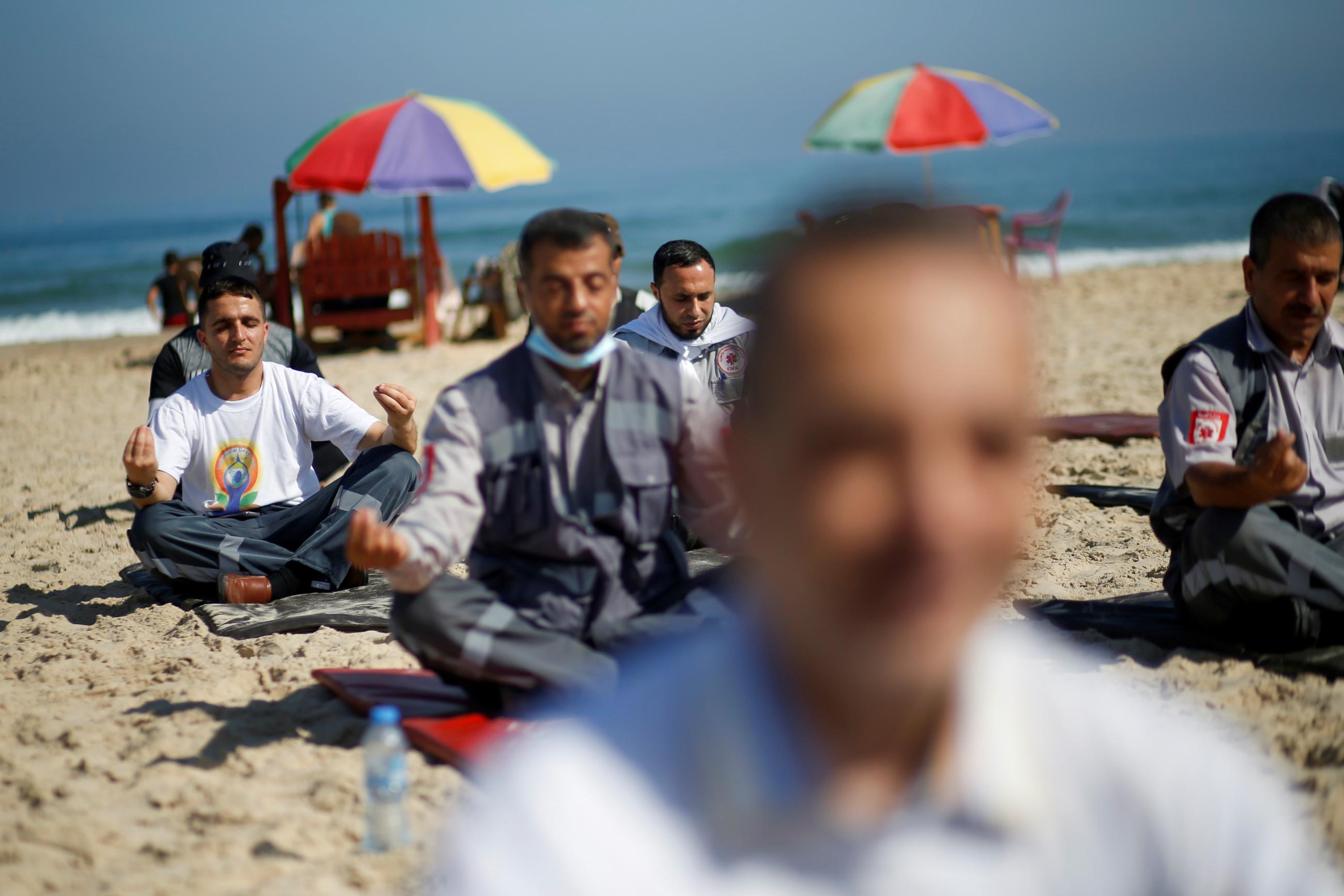 Palestinian paramedics perform yoga on International Day of Yoga on a beach in Gaza City on June 21, 2021. REUTERS/Mohammed Salem