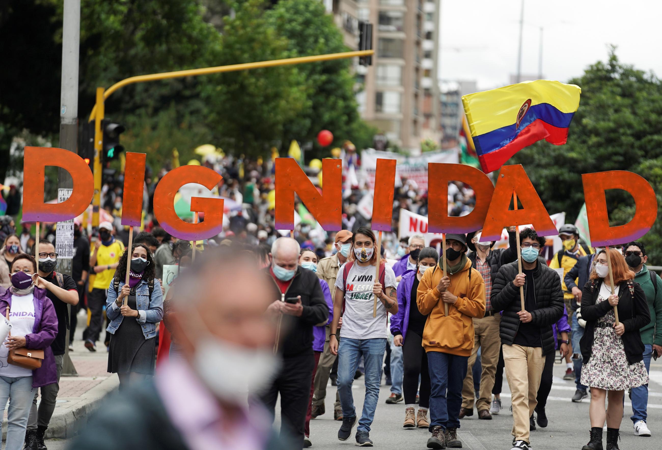 People hold large red. letters that spell “Dignidad” (Dignity) during a protest demanding the government to tackle poverty, police violence, and inequalities in healthcare and education, in Bogota, Colombia on May 26, 2021. 