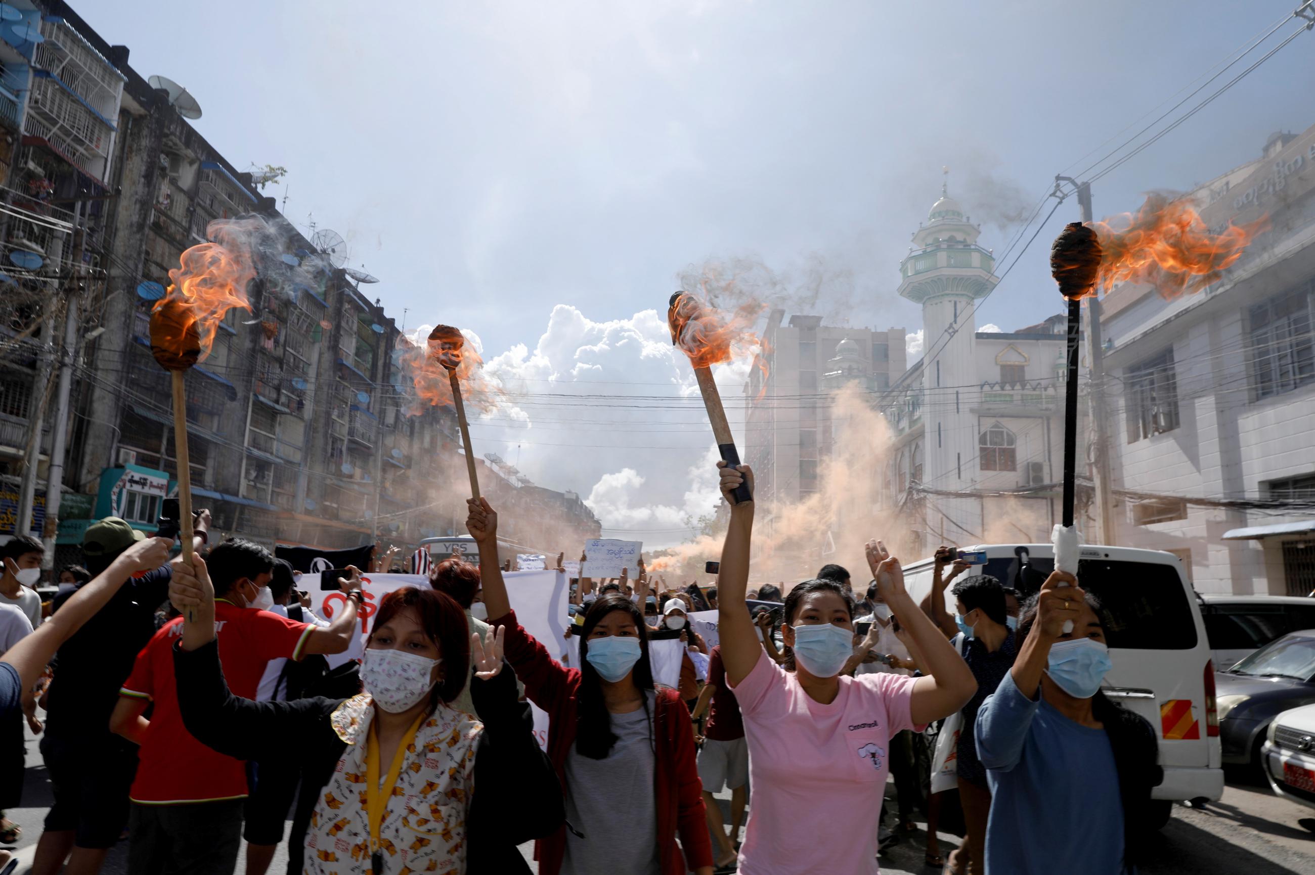 A group of women hold torches as they protest against the military coup in Yangon, Myanmar on July 14, 2021. REUTERS/Stringer