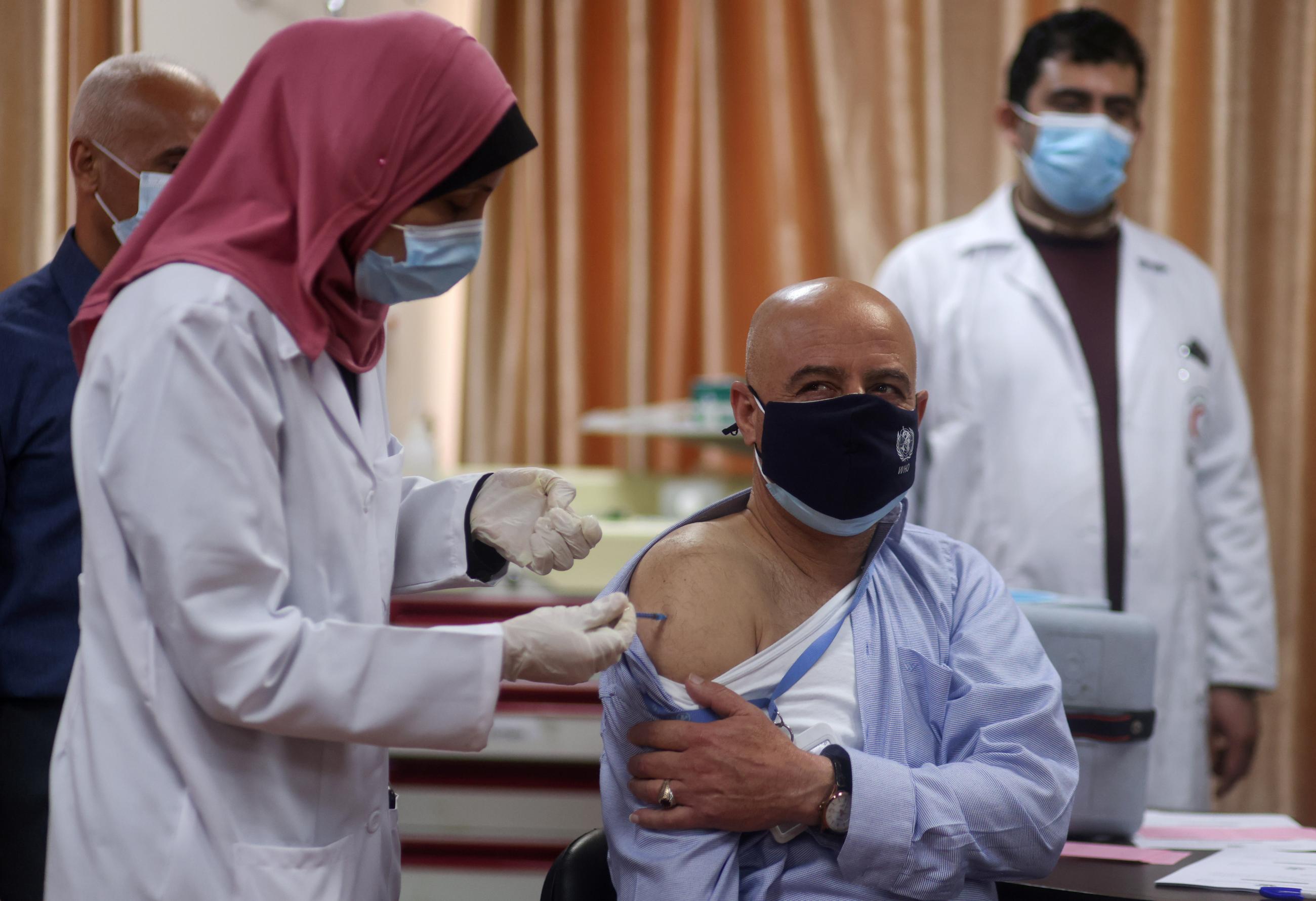A World Health Organization staff member receives a COVID vaccine as part of a drive launched by the WHO to encourage the uptake of vaccines in Gaza City, on March 21, 2021.