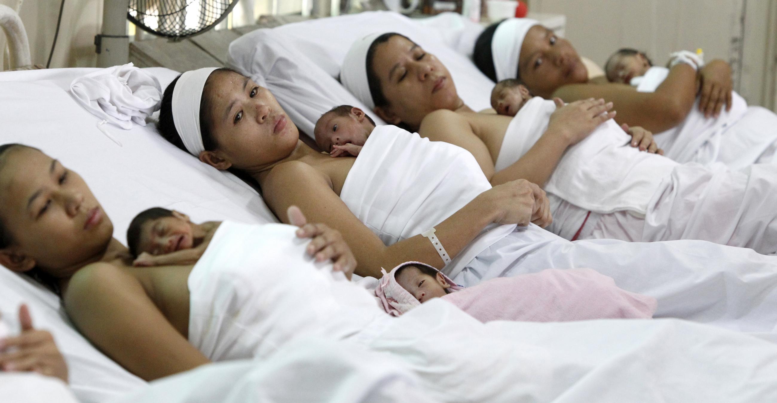 Filipino mothers tuck their babies on their chests after the Philippine government worldwide joined the observance of the 19th World Breastfeeding Week in Manila on August 4, 2010.