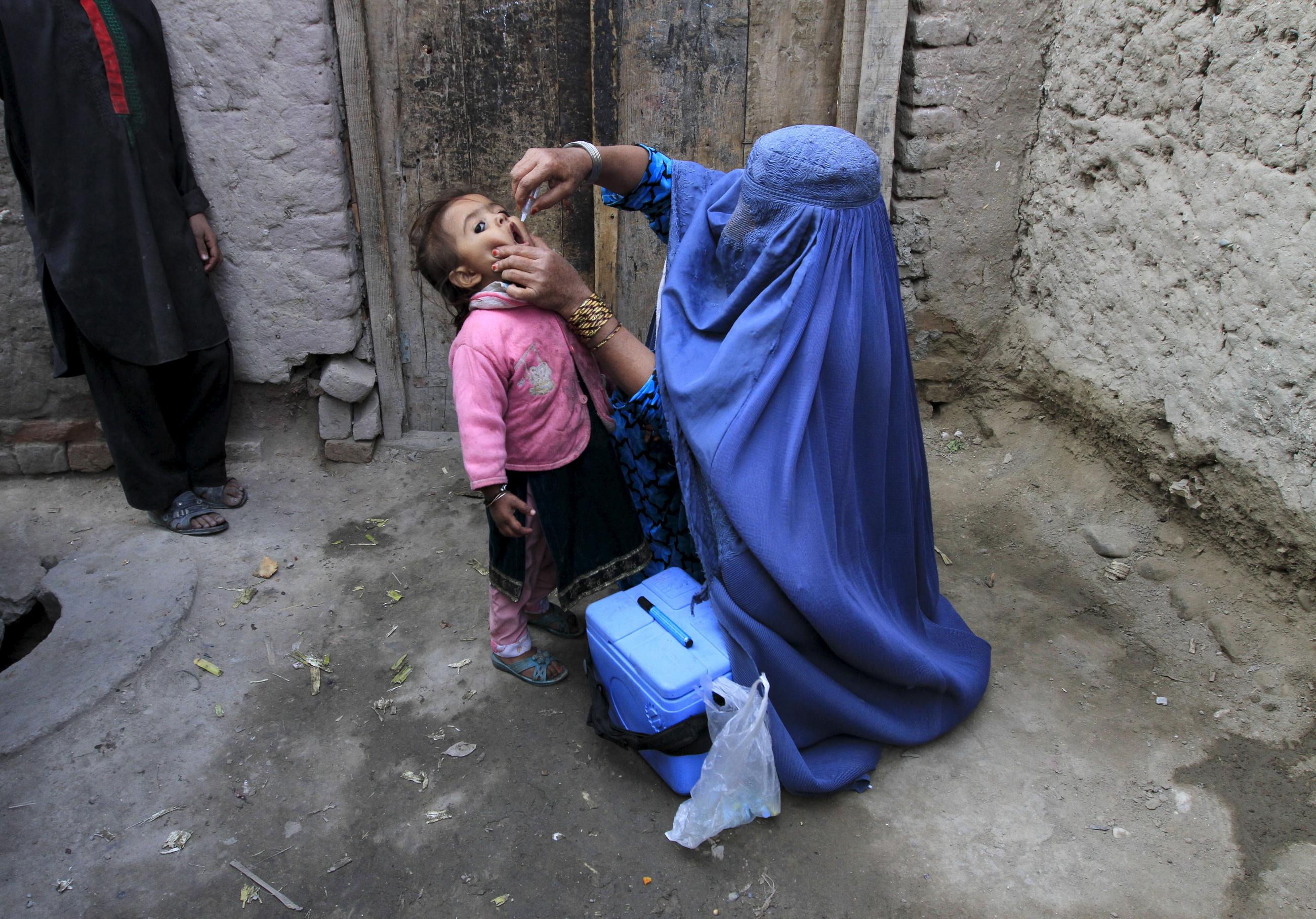 A child receives a polio vaccination during an anti-polio campaign on the outskirts of Jalalabad, Afghanistan, December 1, 2015.