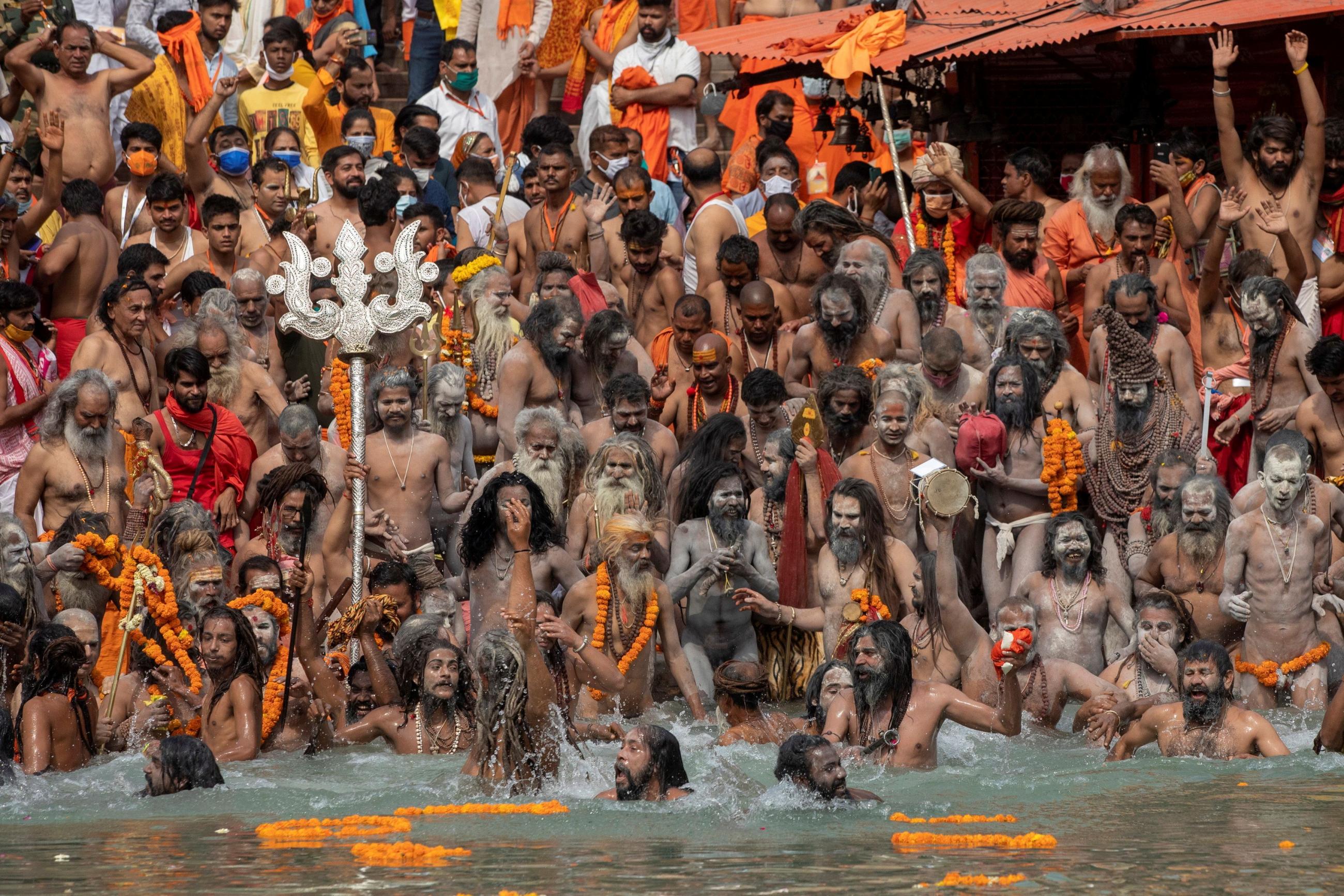 Naga Sadhus, Hindu holy men, take a dip in the Ganges River during Shahi Snan at "Kumbh Mela"—the Pitcher Festival—during the COVID-19 pandemic, in Haridwar, India, on April 12, 2021. 