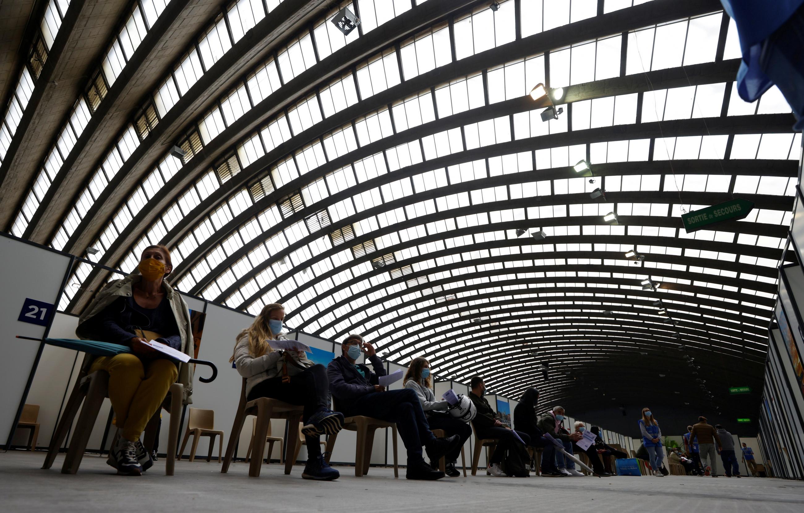 People wait in a vaccination center installed inside the exhibition palace in Nice as part of the coronavirus disease vaccination campaign in France, on April 29, 2021.