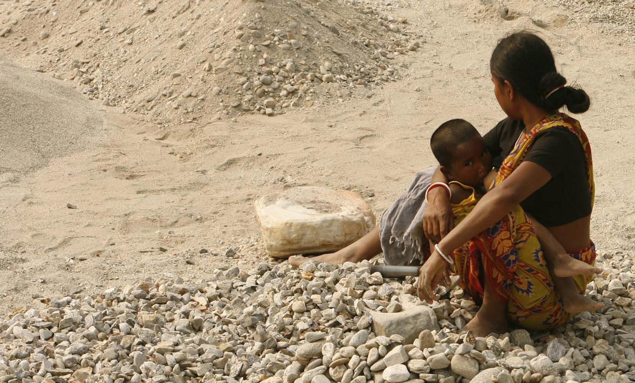 A woman labourer breastfeeds her child on the banks of river Balason on the outskirts of the eastern Indian city of Siliguri March 5, 2009