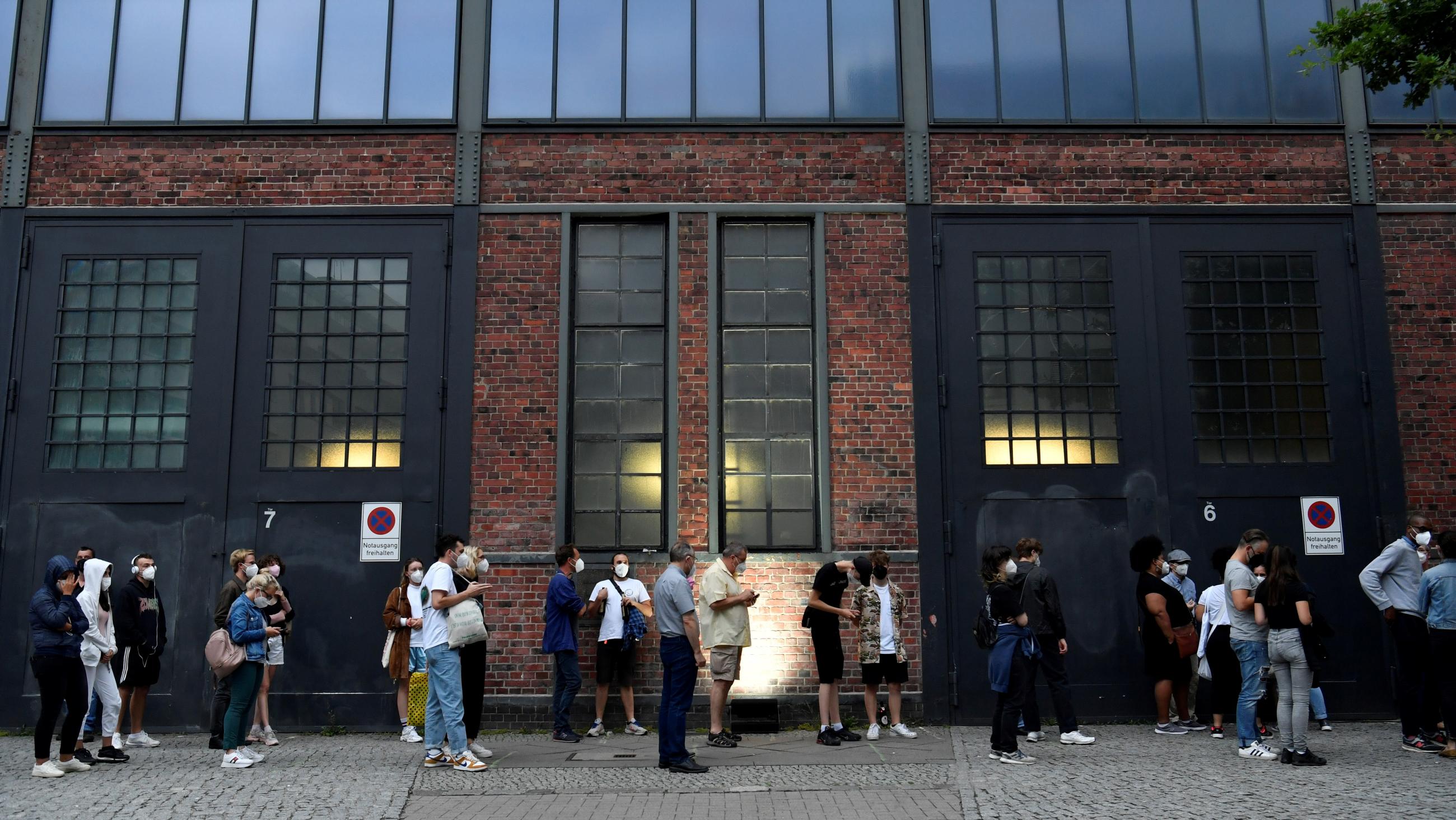 People line-up for COVID-19 vaccines during a night of vaccinations with music, at the Arena Treptow centre in Berlin, Germany, on August 9, 2021. 