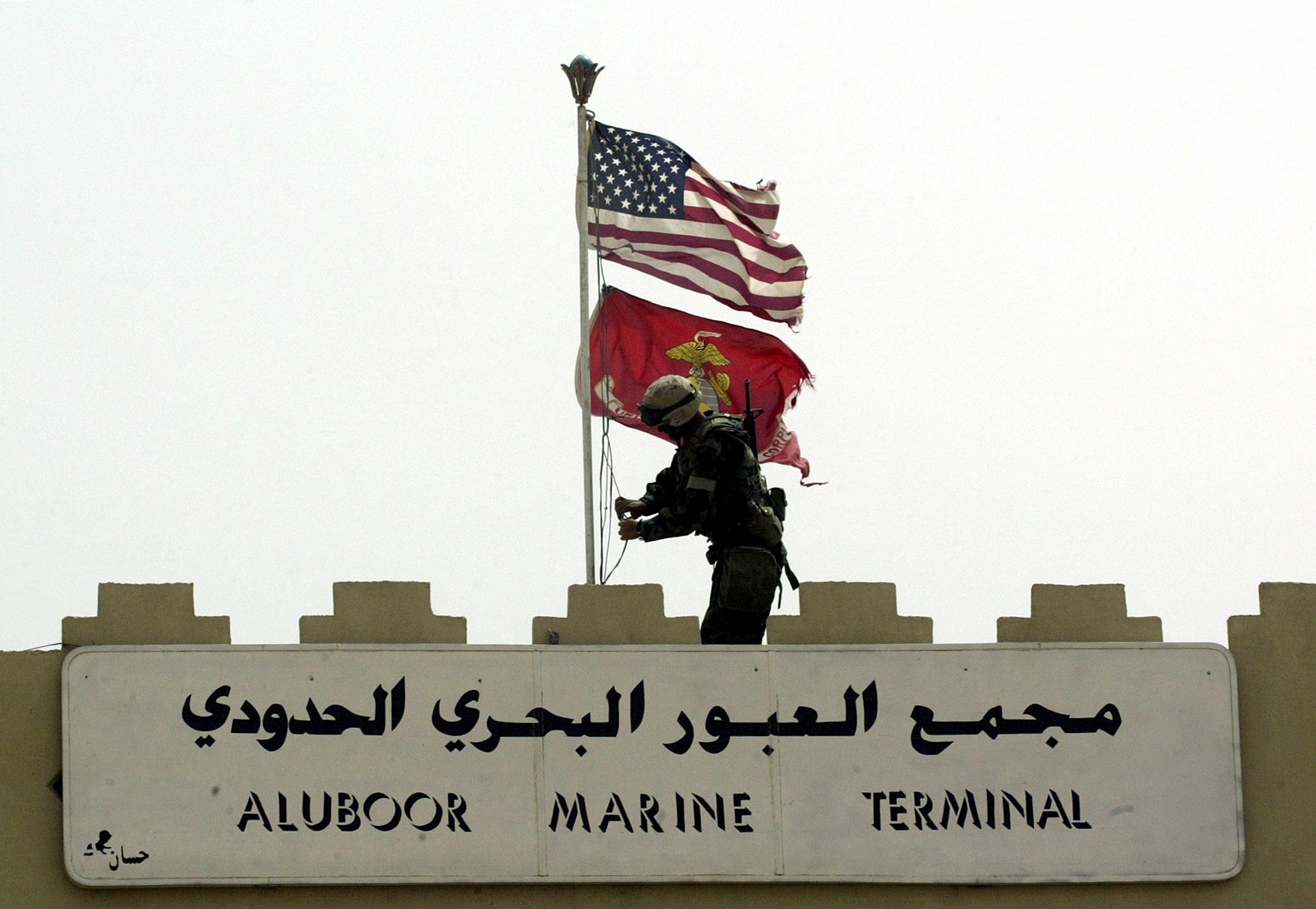 A Marine of the U.S. Marine Expeditionary Unit (MEU) Fox Company 'Raiders' replaces the Iraqi flag at the entrance to Iraq's main port of Umm Qasr on March 21, 2003 