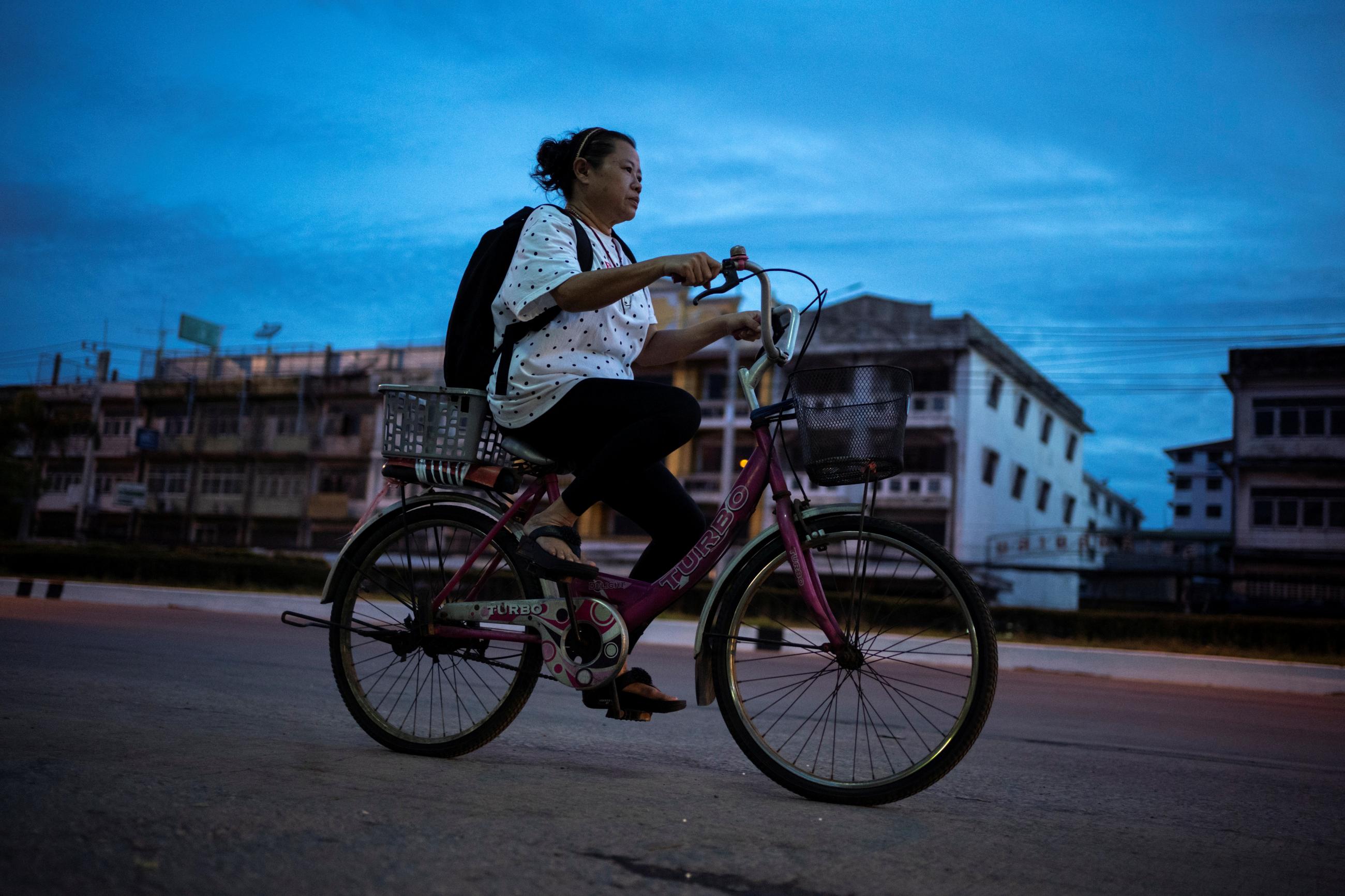 Unyakarn Booprasert, 59, who tried to take her own life in April 2020, cycles to a hospital appointment in Samut Sakhon province, Thailand, on May 29, 2020. 